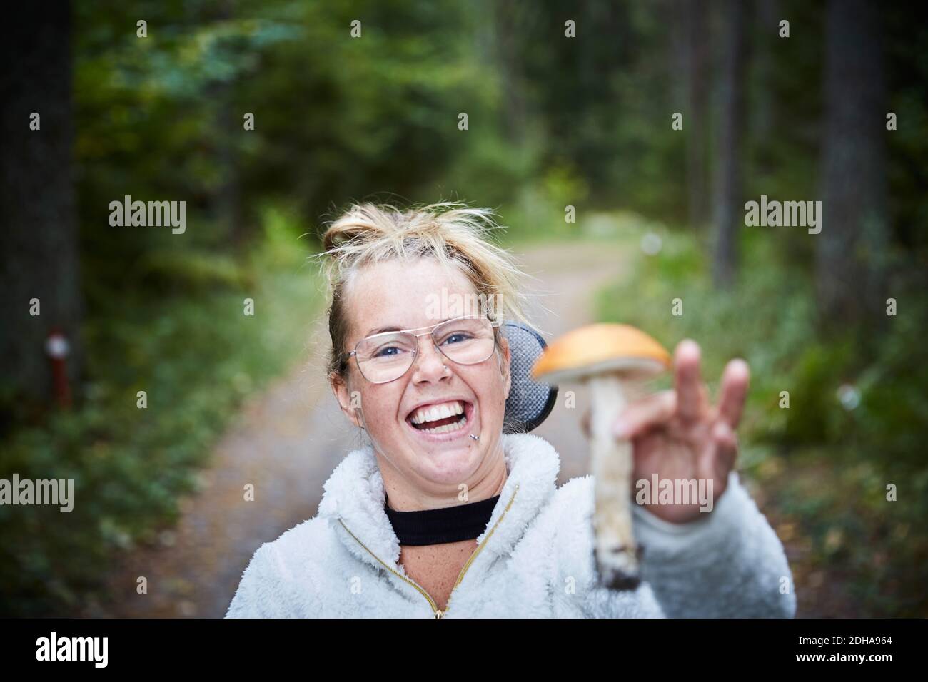 Porträt einer behinderten jungen Frau, die Pilze im Wald hält Stockfoto