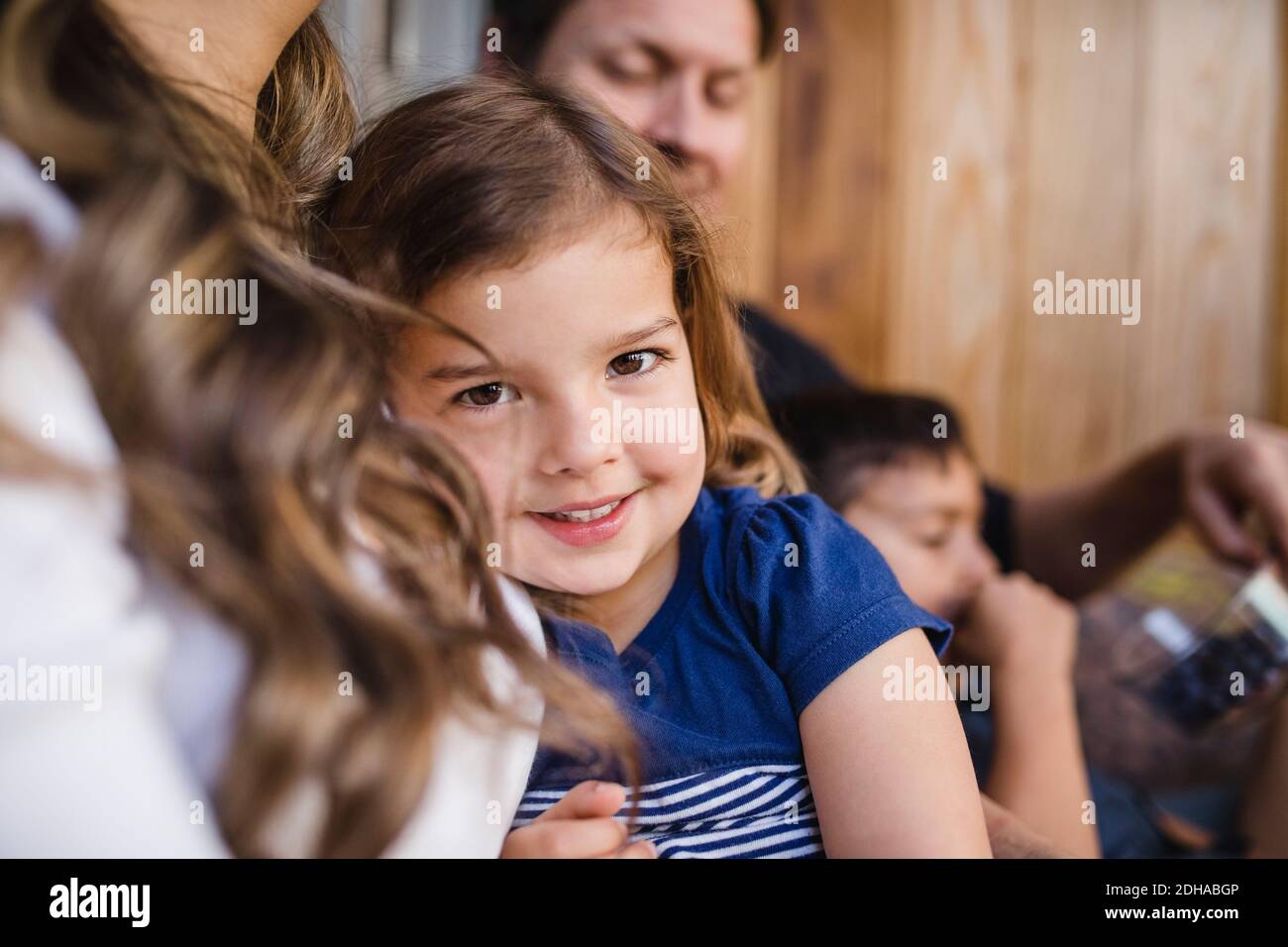 Portrait von lächelndem Mädchen mit Familie sitzen Stockfoto