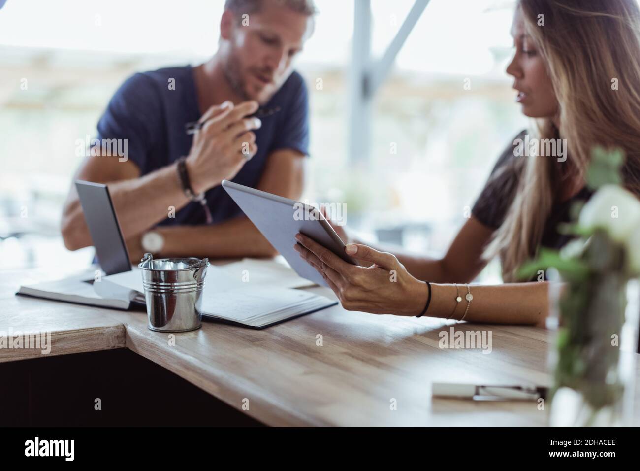 Geschäftsfrau mit digitalem Tablet sitzt mit Mitarbeiter im Restaurant Stockfoto