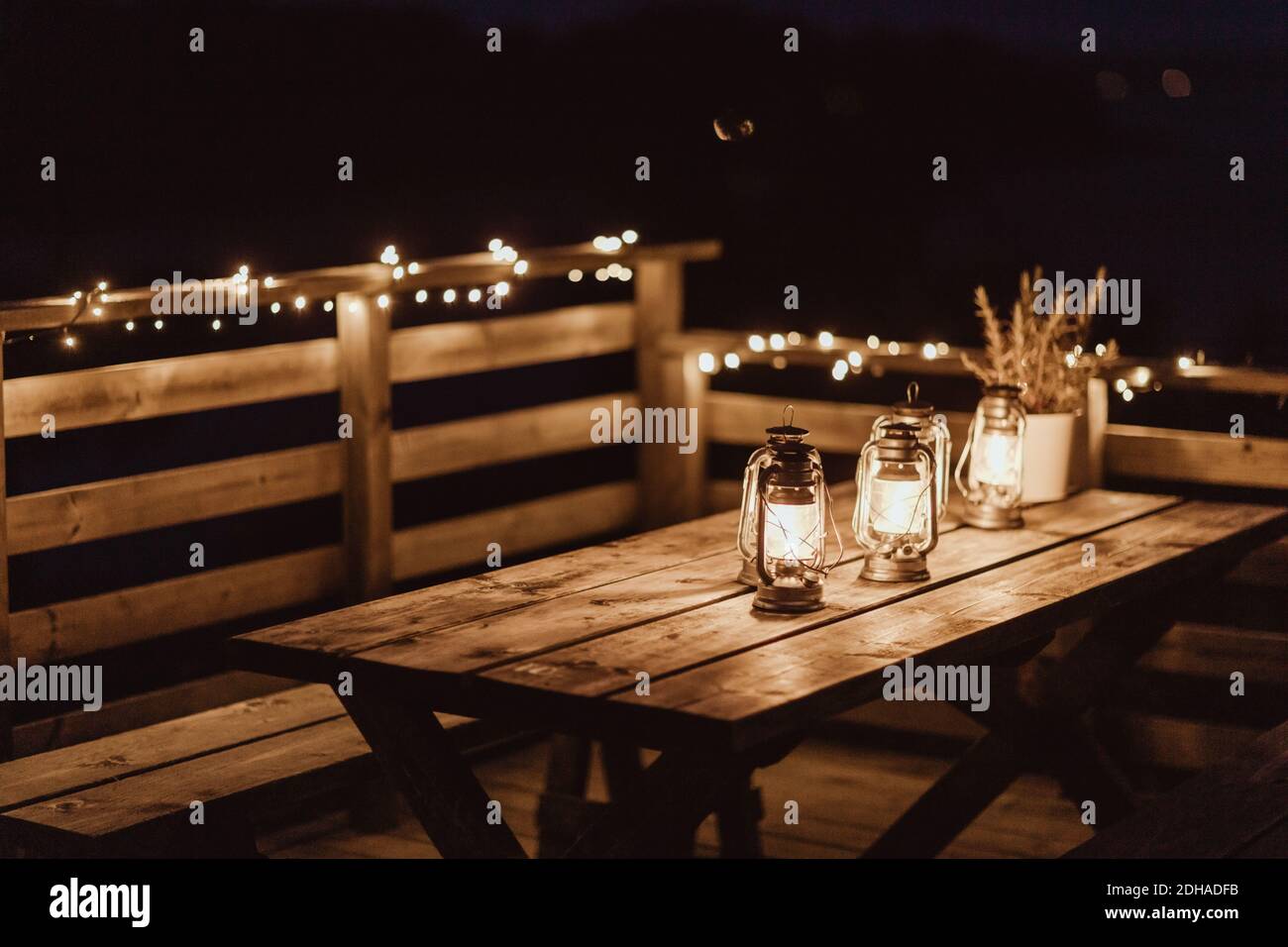 Beleuchtete Laternen auf leerem Tisch im Restaurant während der Nacht Stockfoto