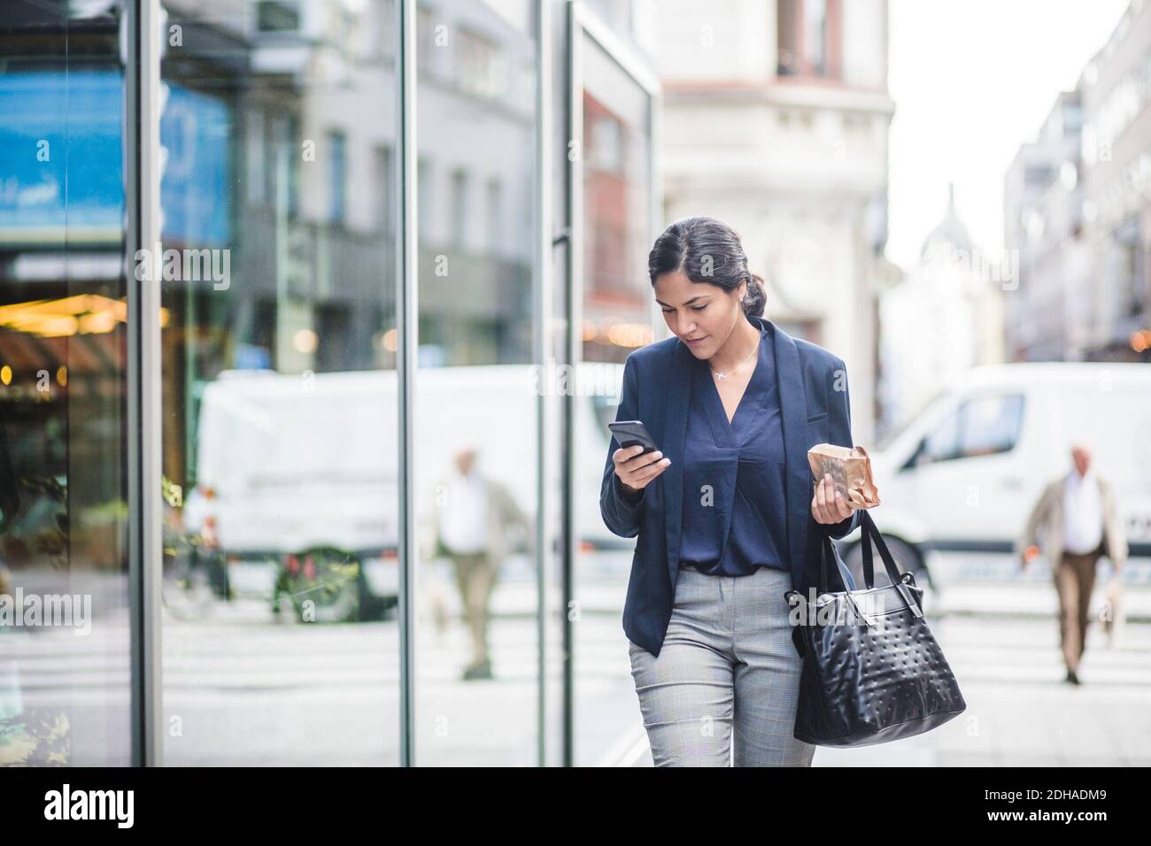 Geschäftsfrau, die beim Gehen durch das Gebäude telefoniert Stockfoto