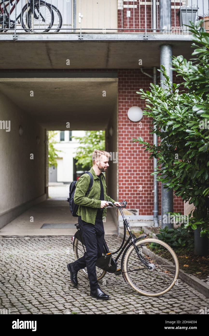 Männlicher Unternehmer mit Fahrrad zu Fuß Stockfoto
