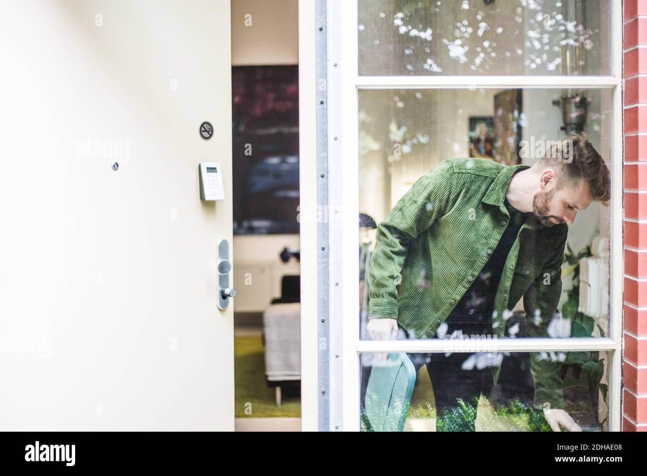 Männlicher Unternehmer durch Glasfenster gesehen Stockfoto