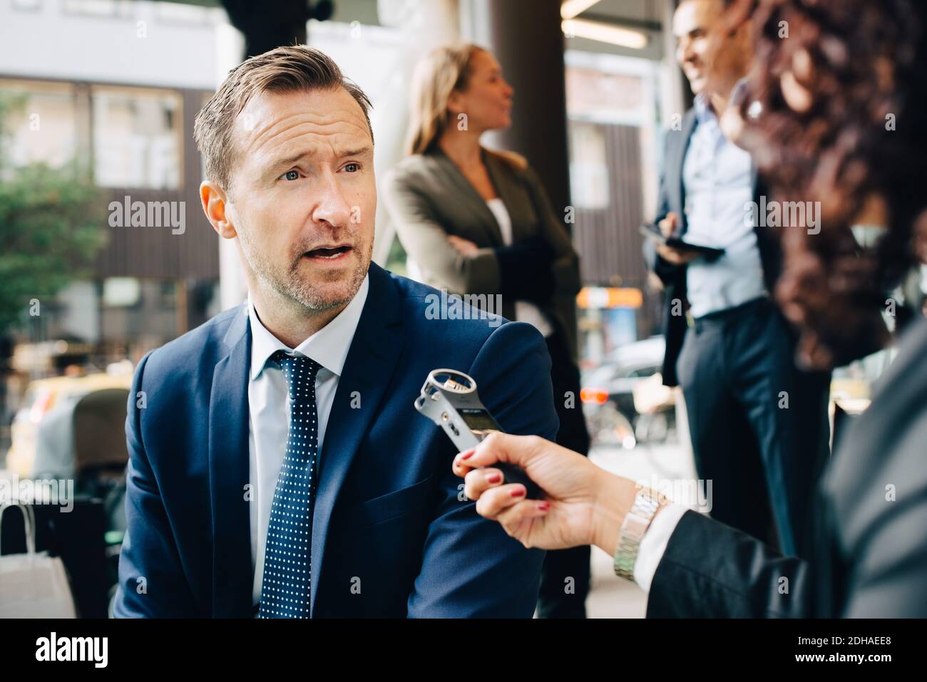 Zugeschnittenes Bild einer Frau, die einen Geschäftsmann in der Stadt interviewt Stockfoto