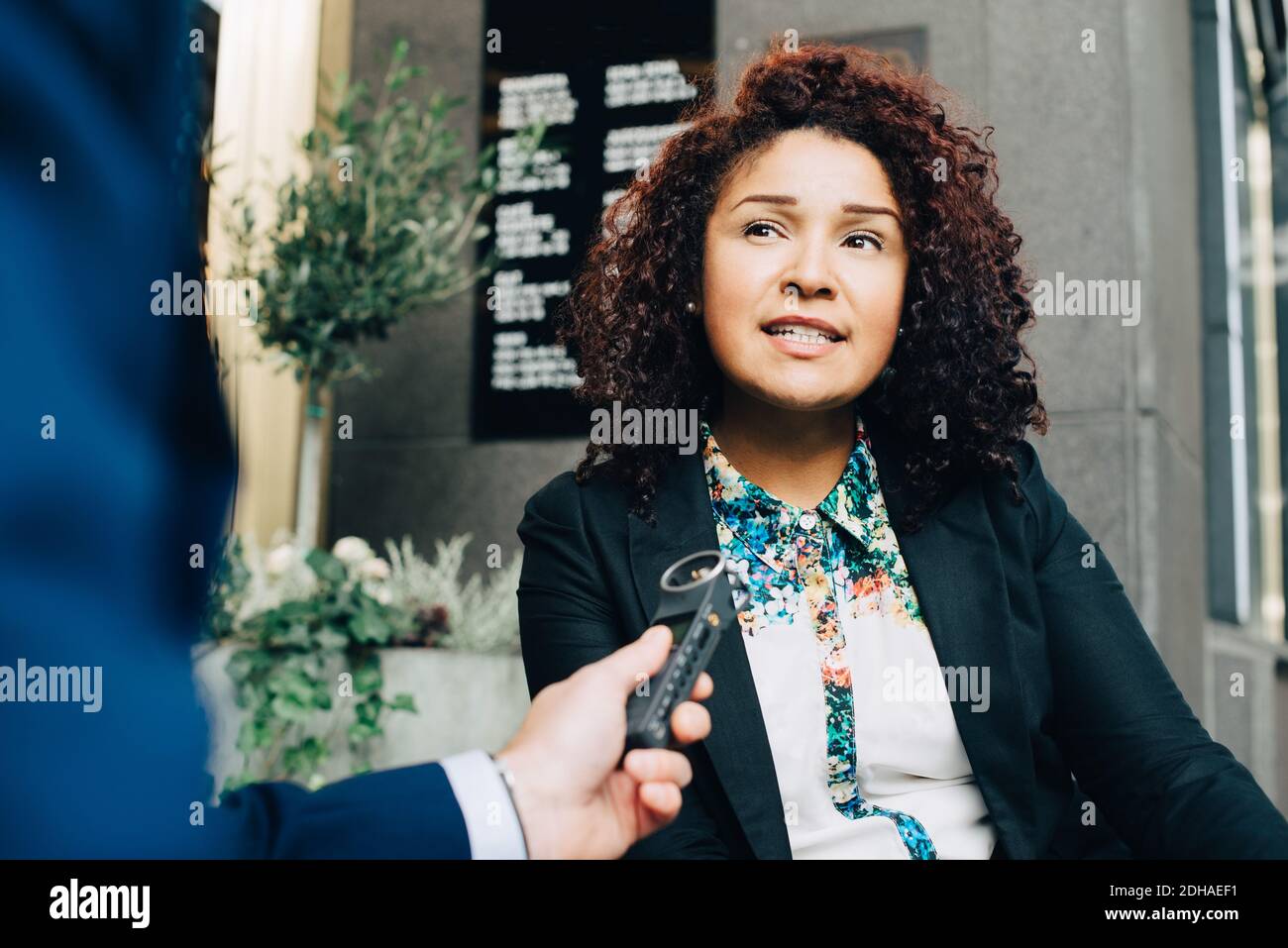 Beschnittenes Bild des Mannes, der Geschäftsfrau in der Stadt interviewt Stockfoto