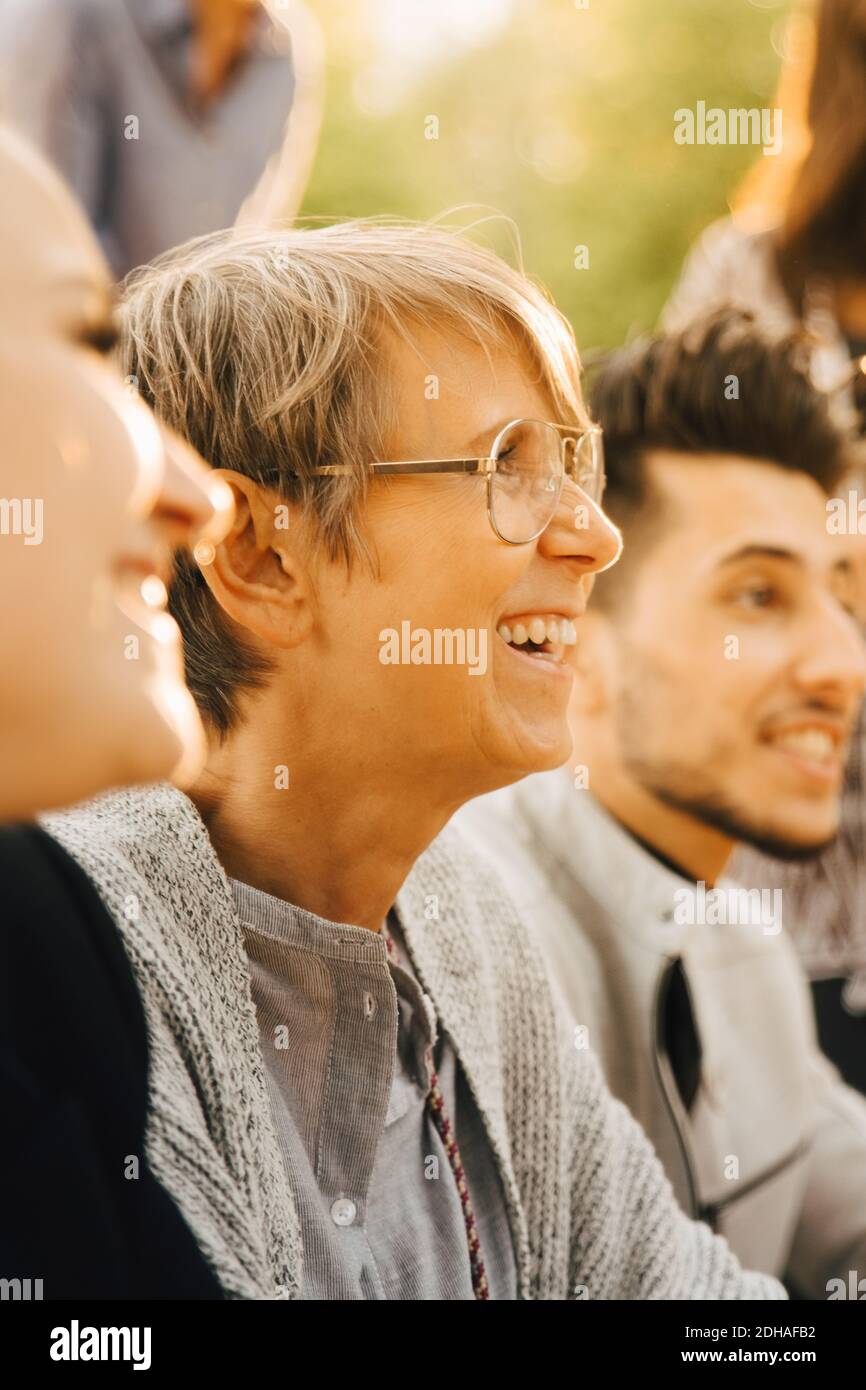 Männliche und weibliche Freunde lächeln bei der gesellschaftlichen Zusammenkunft Stockfoto