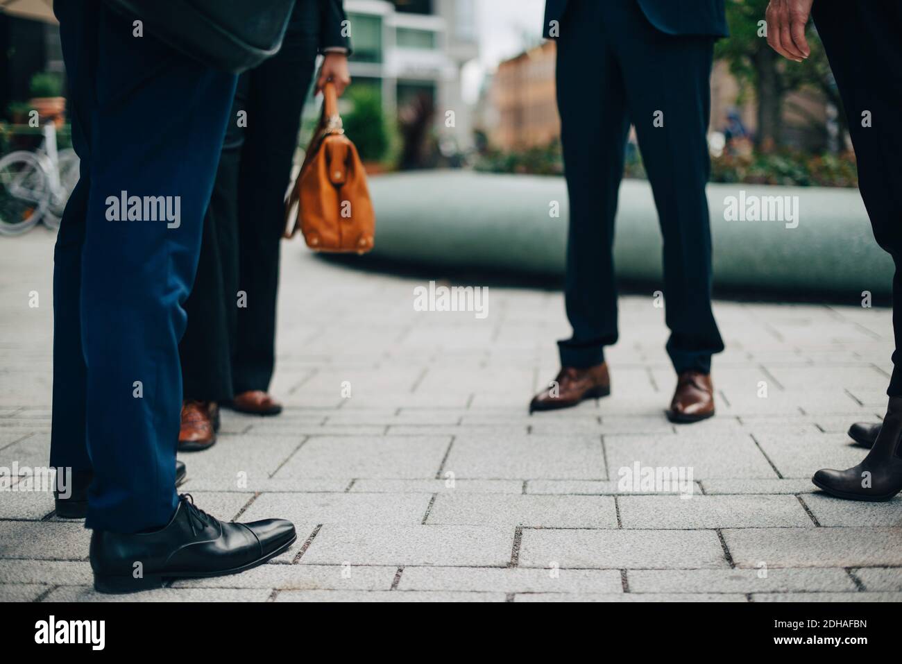 Niedriger Teil von Geschäftsleuten, die auf Fußwegen in der Stadt stehen Stockfoto