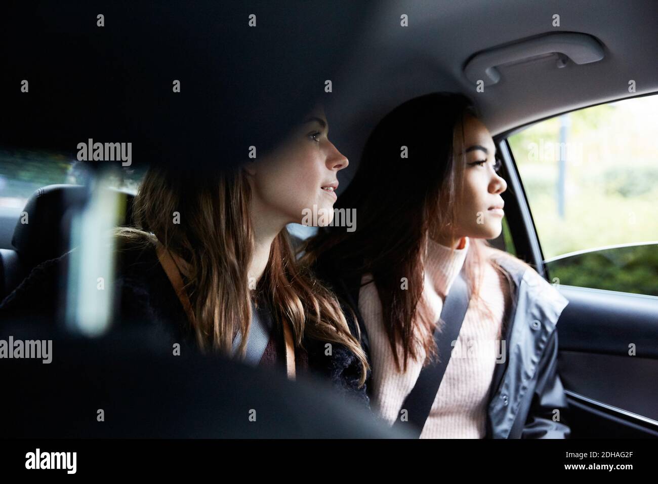 Freundinnen schauten durch das Fenster, während sie im Taxi saßen Stadt Stockfoto