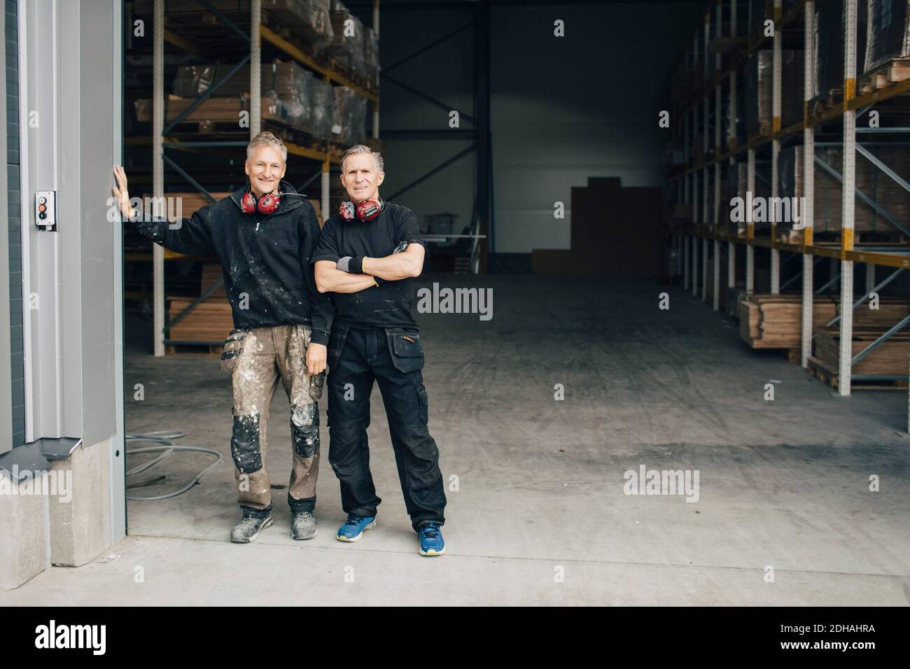 In voller Länge Porträt von selbstbewussten Arbeitern im Eingang zu stehen Branche Stockfoto