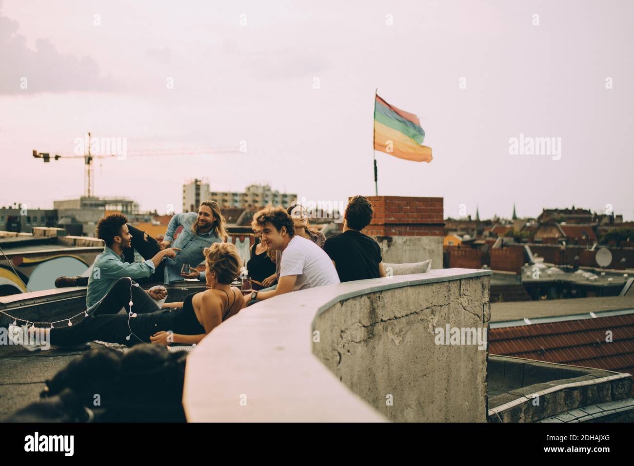 Freunde genießen Dachparty in der Stadt gegen den Himmel Stockfoto