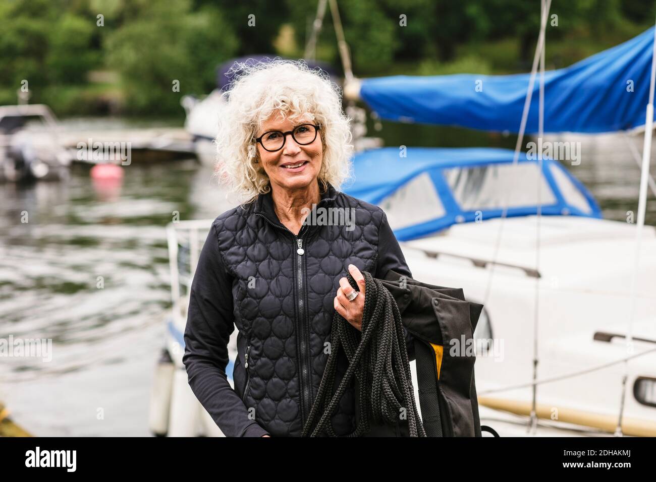 Porträt einer selbstbewussten älteren Frau mit Rettungsweste und Seil Während des Bootskurses Stockfoto