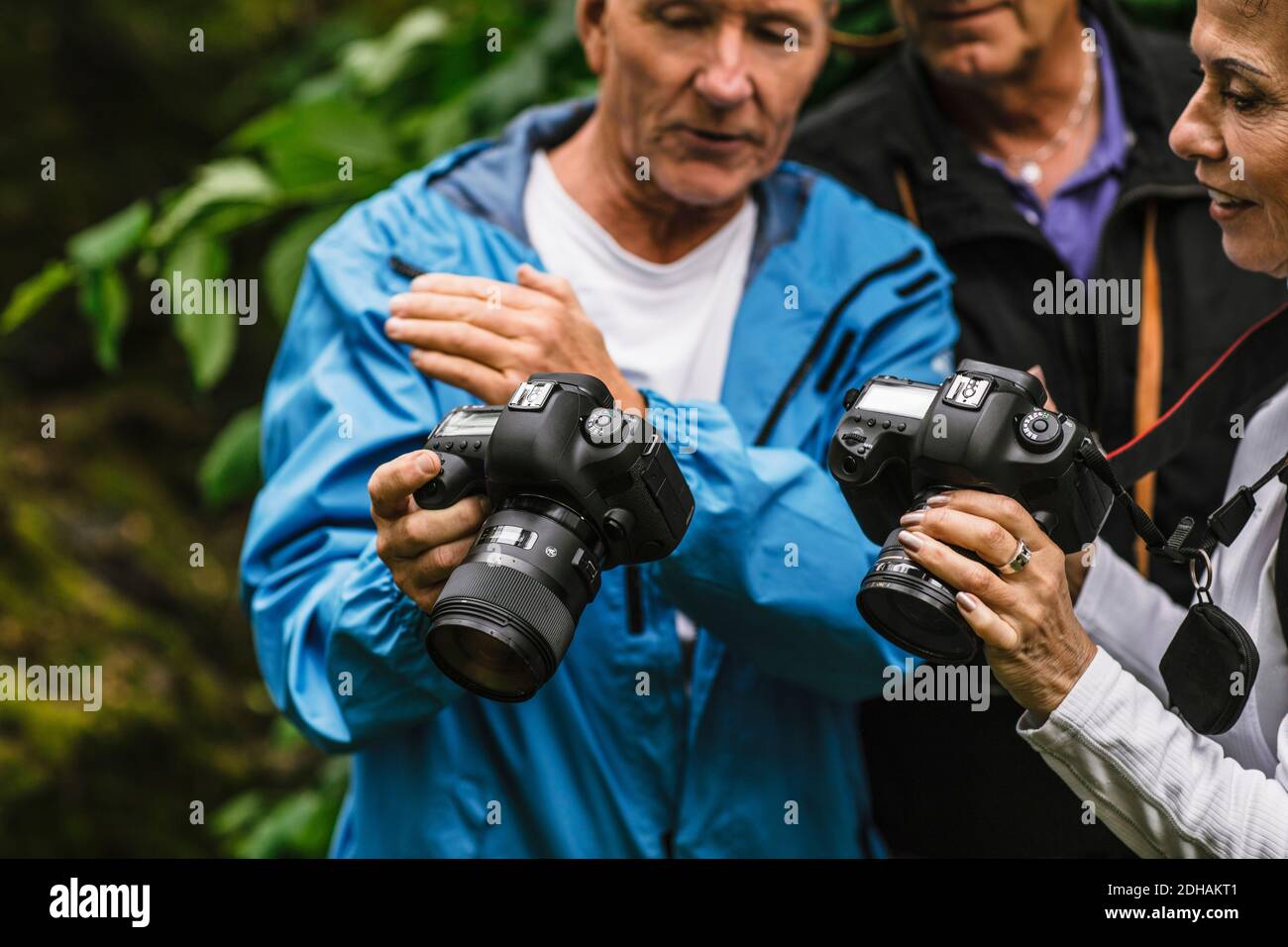 Älterer Mann, der während des Fotografiekurses der Lehrerin die Kamera zeigt Stockfoto