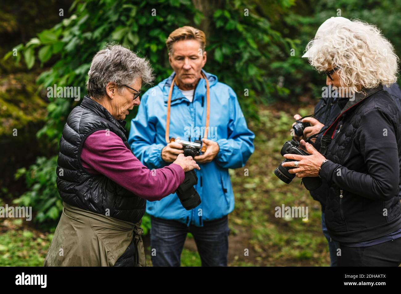 Ältere Frauen und Männer mit Kamera während des Fotografiekurses Stockfoto