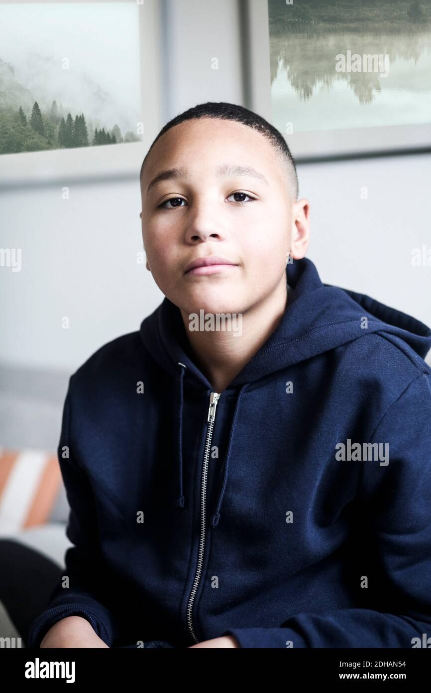 Portrait eines Jungen im Teenageralter, der zu Hause eine Kapuzenjacke trägt Stockfoto