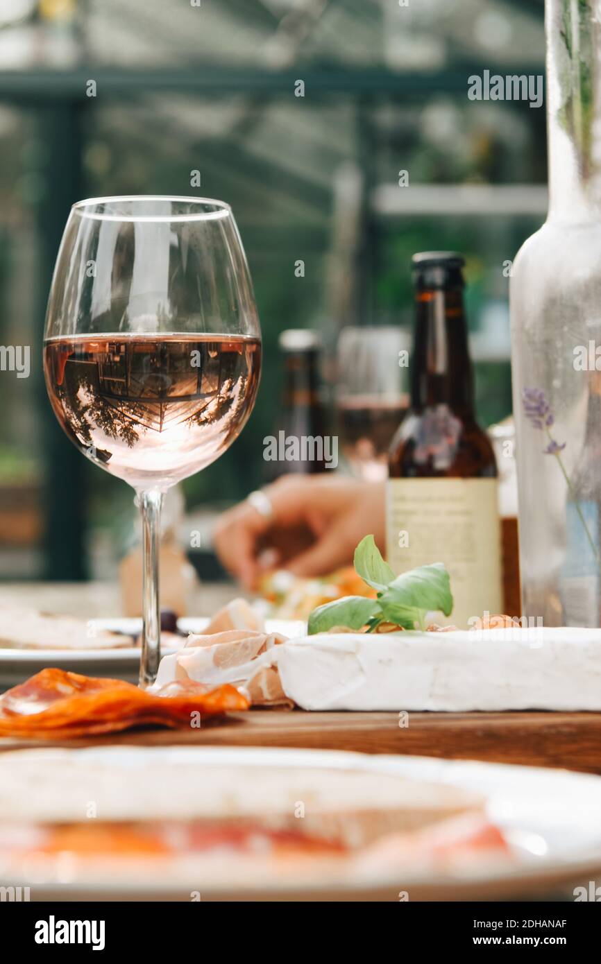 Nahaufnahme des Weinglases beim Essen auf dem Esstisch im Hof Stockfoto