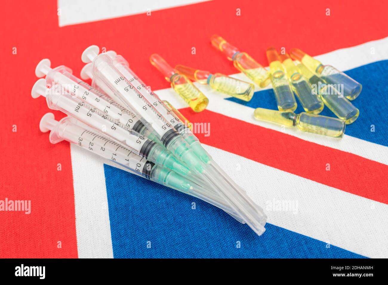 Hypodermische Spritzen und Glasampullen auf Union Jack. Für britischen Covid-Impfstoff, Coronavirus-Impfstoff, britischen Covid-Cure-Impfstoff und britisches Impfstoffproduktionskonzept. Stockfoto