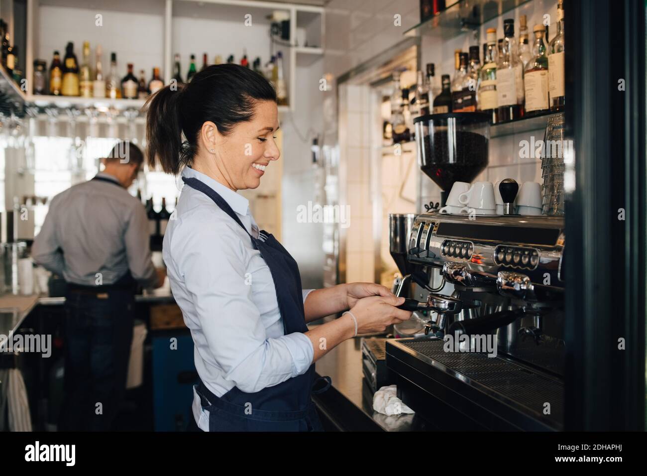 Lächelnder Barista mit Kaffeemaschine im Restaurant Stockfoto