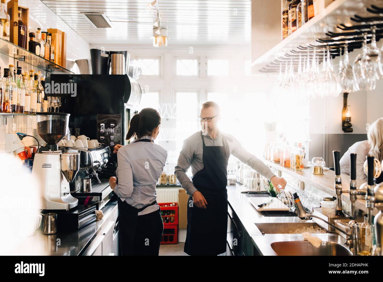 Männliche und weibliche Mitarbeiter arbeiten in der Küche im Restaurant Stockfoto