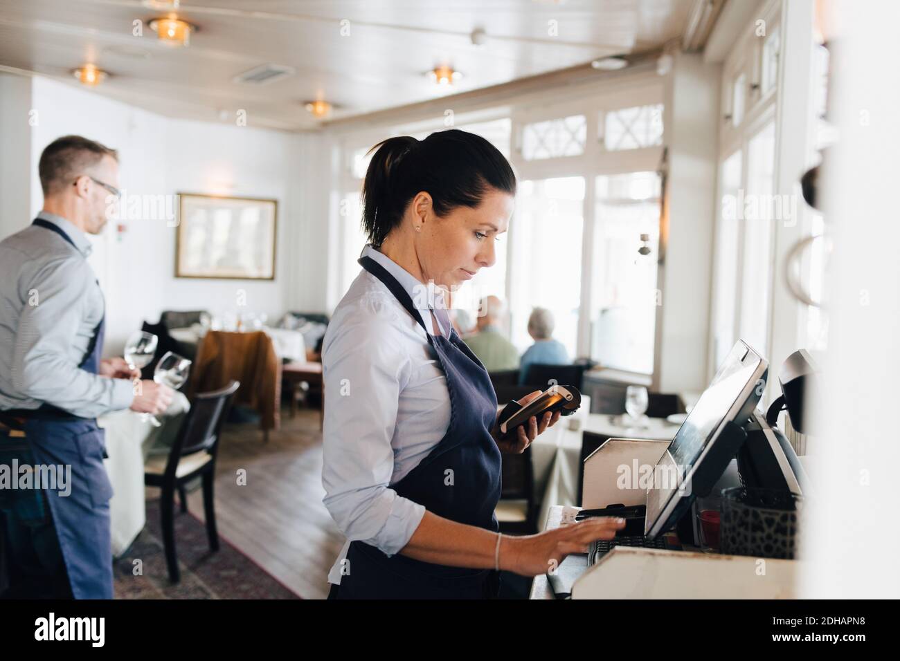 Frau benutzt Computer im Restaurant Stockfoto