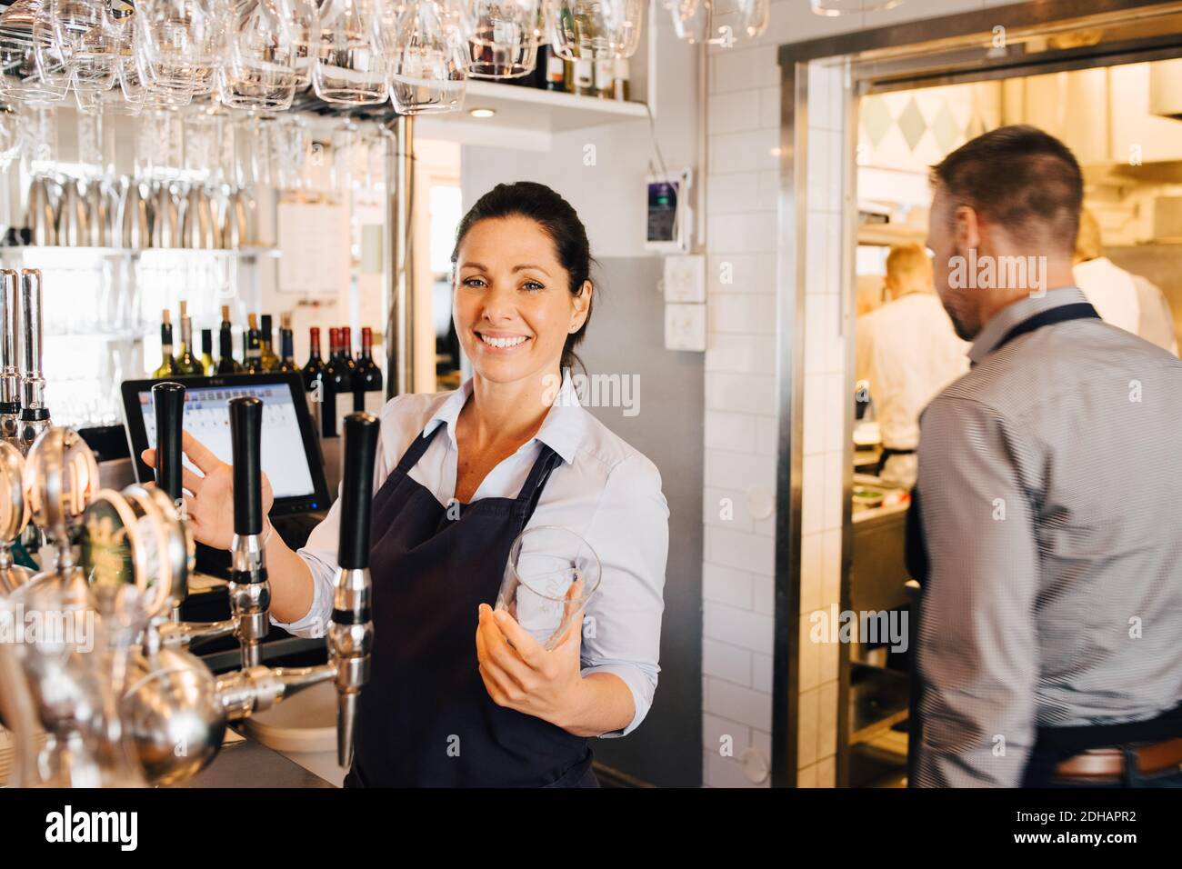 Männliche und weibliche Besitzer stehen im Restaurant Stockfoto