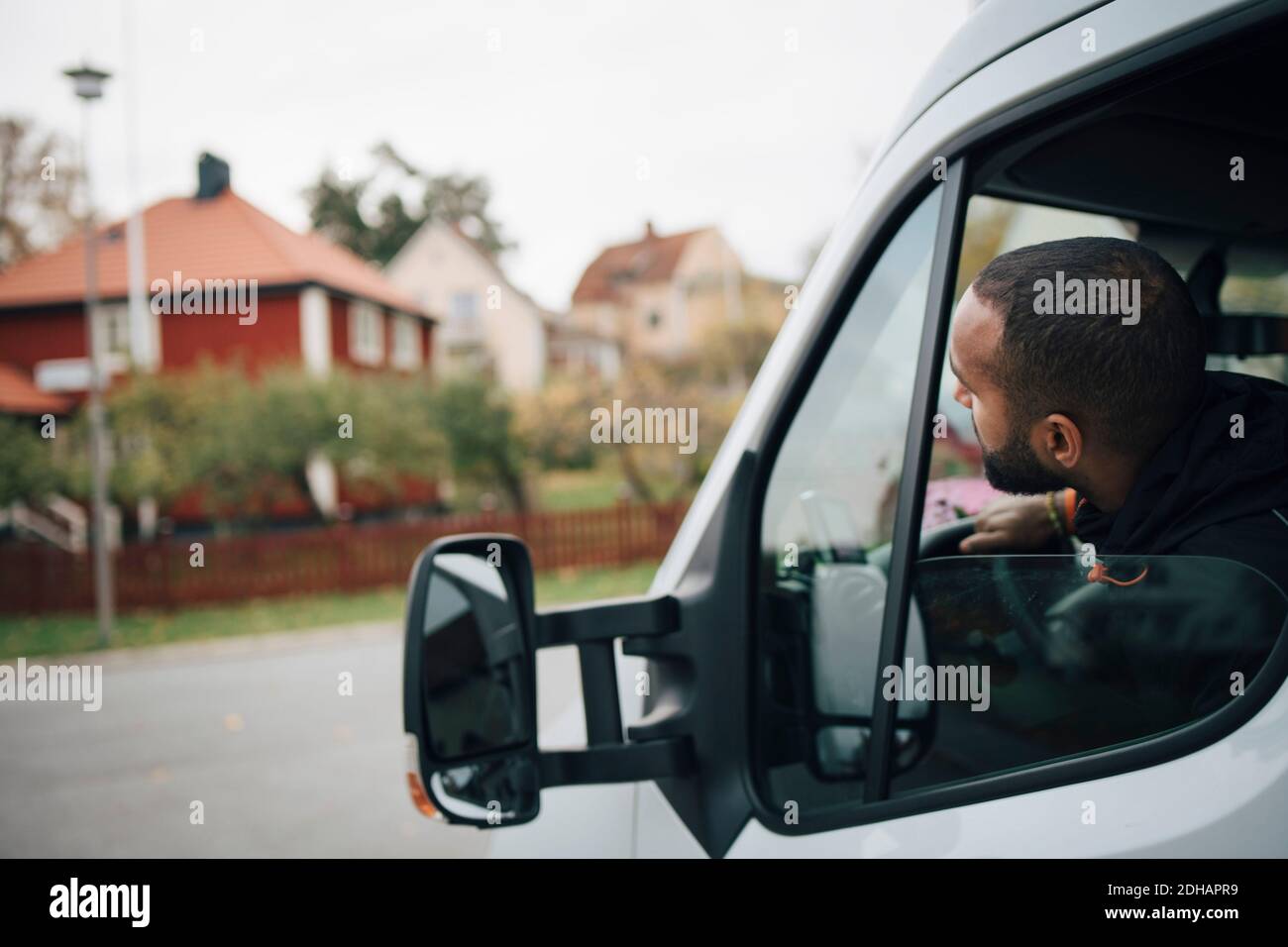 Männlicher Arbeiter, der in einem Lieferwagen in der Stadt sitzt Stockfoto