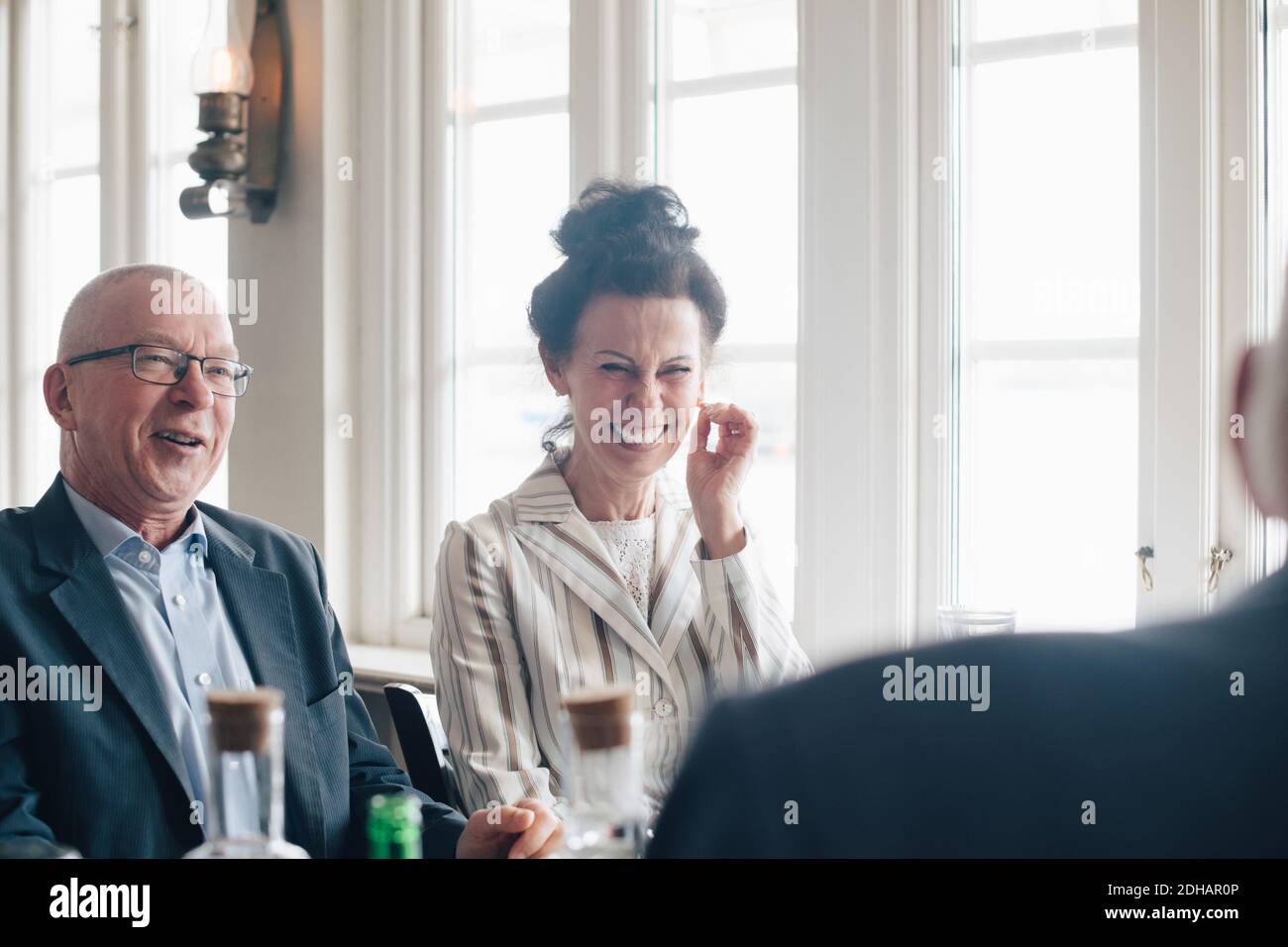 Ältere Freunde lächeln, während sie im Restaurant sitzen Stockfoto