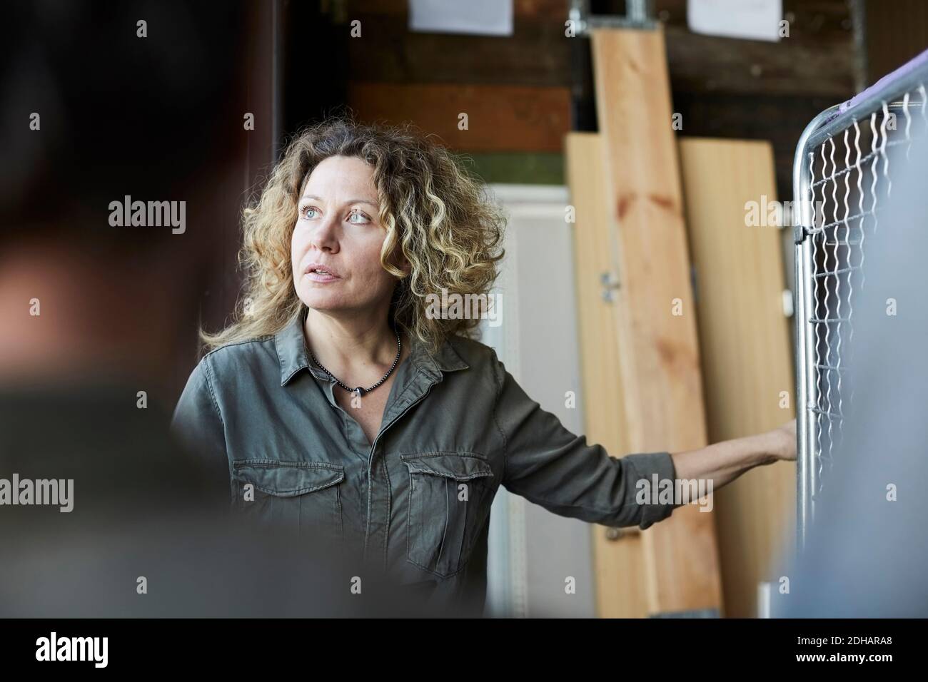 Reife weibliche Freiwillige mit blonden lockigen Haaren stehen vor Des Mitarbeiters im Lager Stockfoto