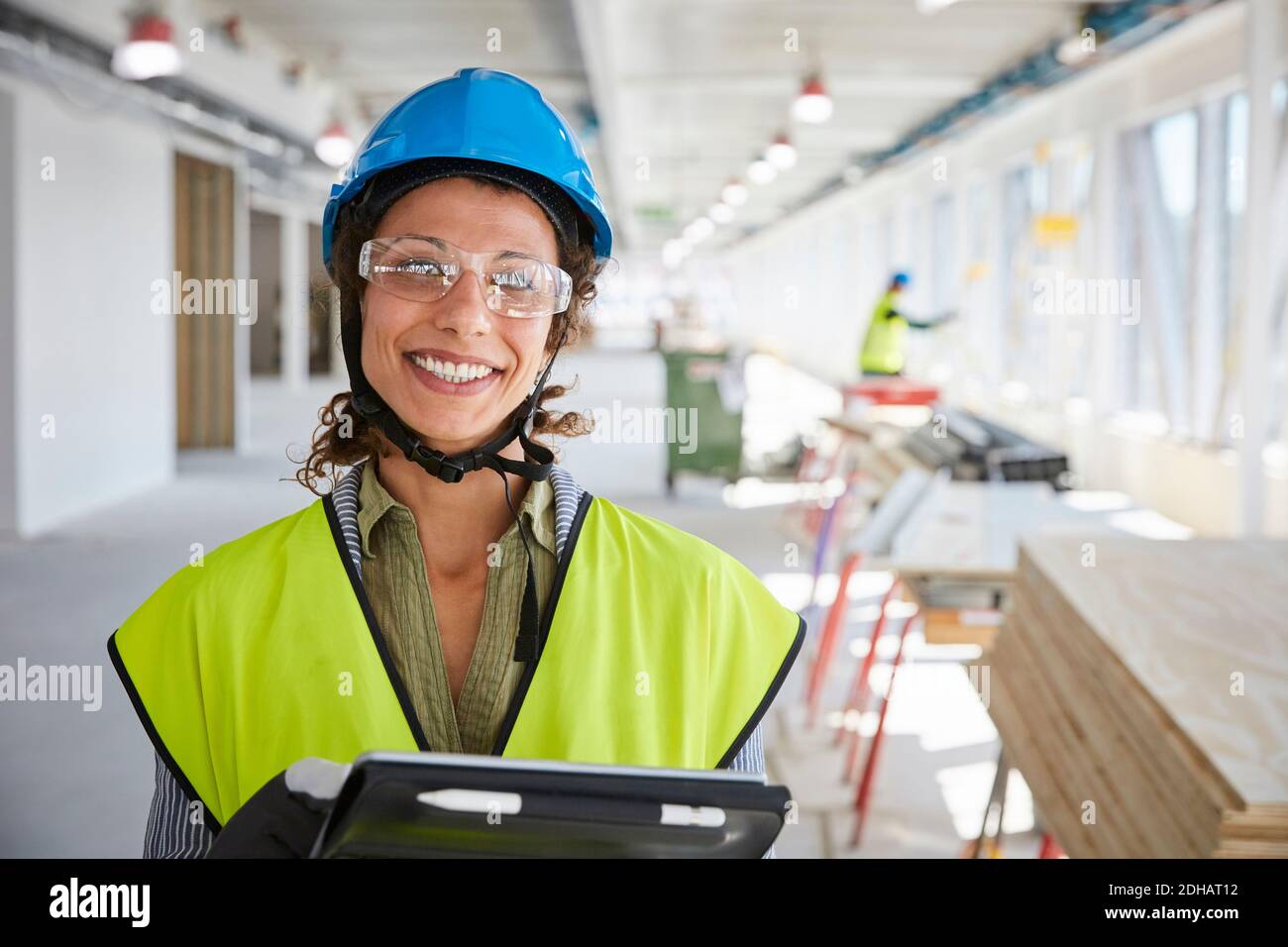 Portrait einer lächelnden Vorarbeiterin mit digitalem Tablet bei der Konstruktion Standort Stockfoto