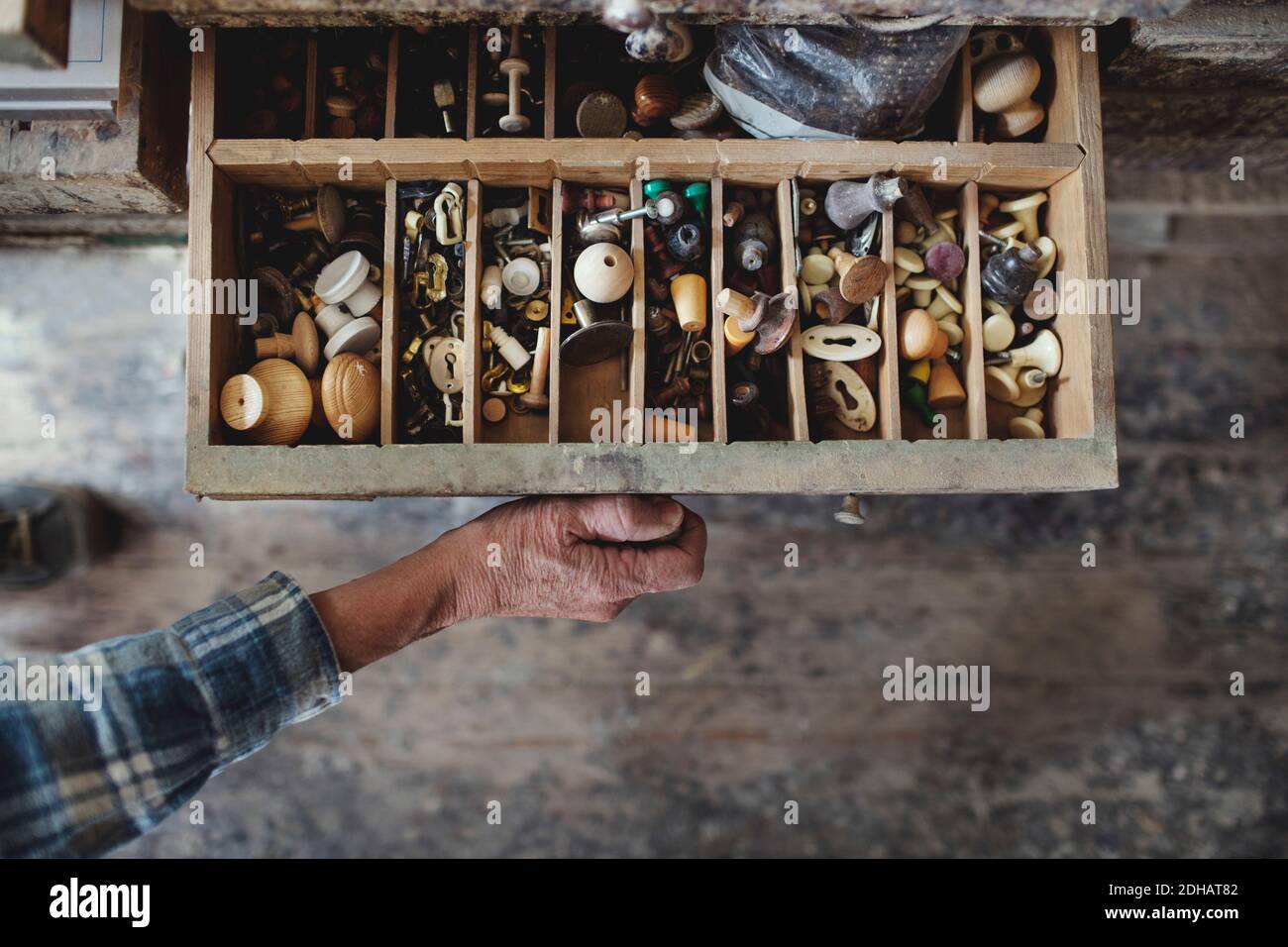 Zugeschnittenes Bild von Handwerker Öffnung Schublade mit Knöpfen in der Werkstatt Stockfoto