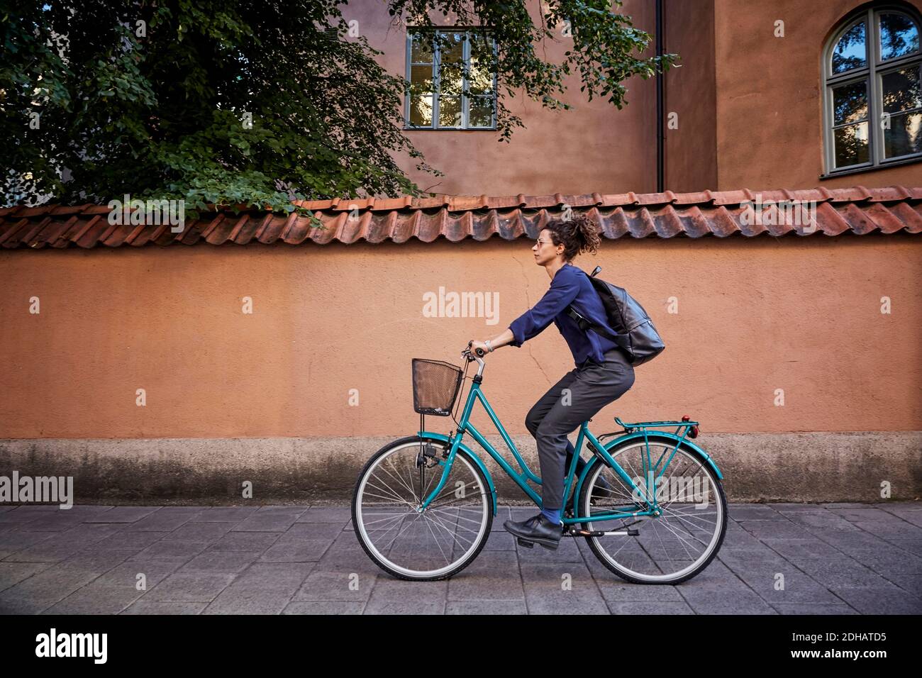 Seitenansicht einer Architektin, die auf der Straße Fahrrad fährt Stadt Stockfoto