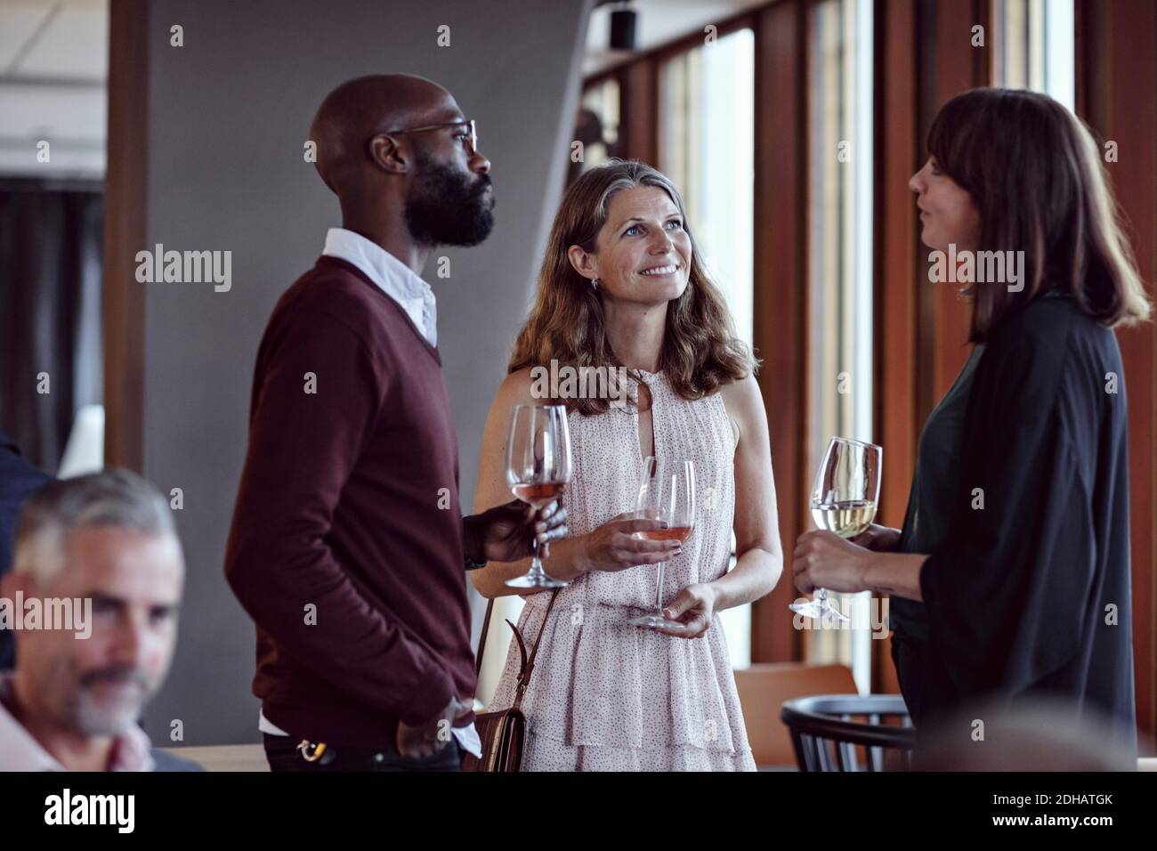 Männliche und weibliche Kollegen reden während sie Getränke in der Party genießen Nach der Arbeit Stockfoto