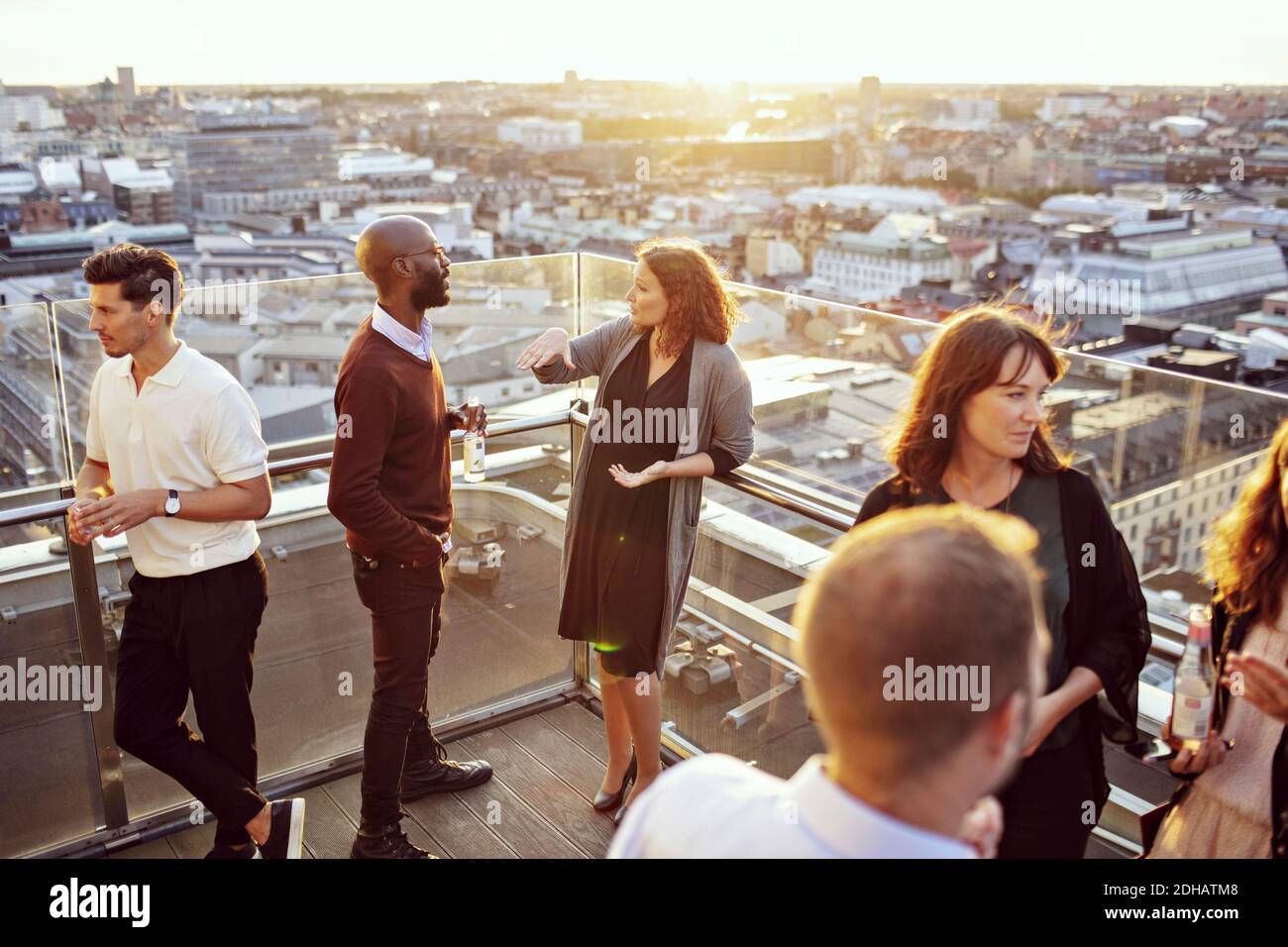Geschäftskollegen diskutieren auf der Terrasse nach der Arbeitsfeier Stockfoto