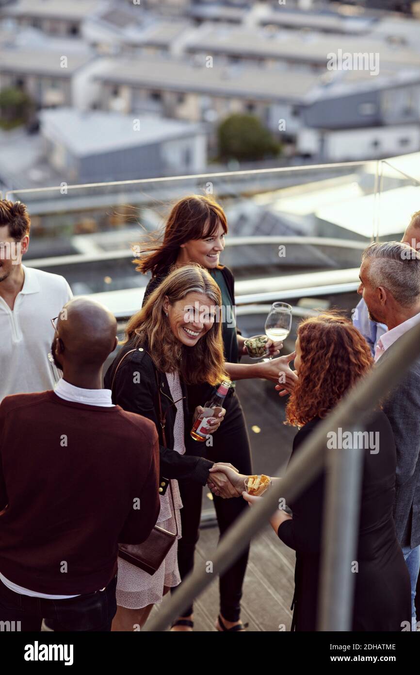 Glückliche Fachleute begrüßen bei der Party auf der Terrasse nach der Arbeit Stockfoto