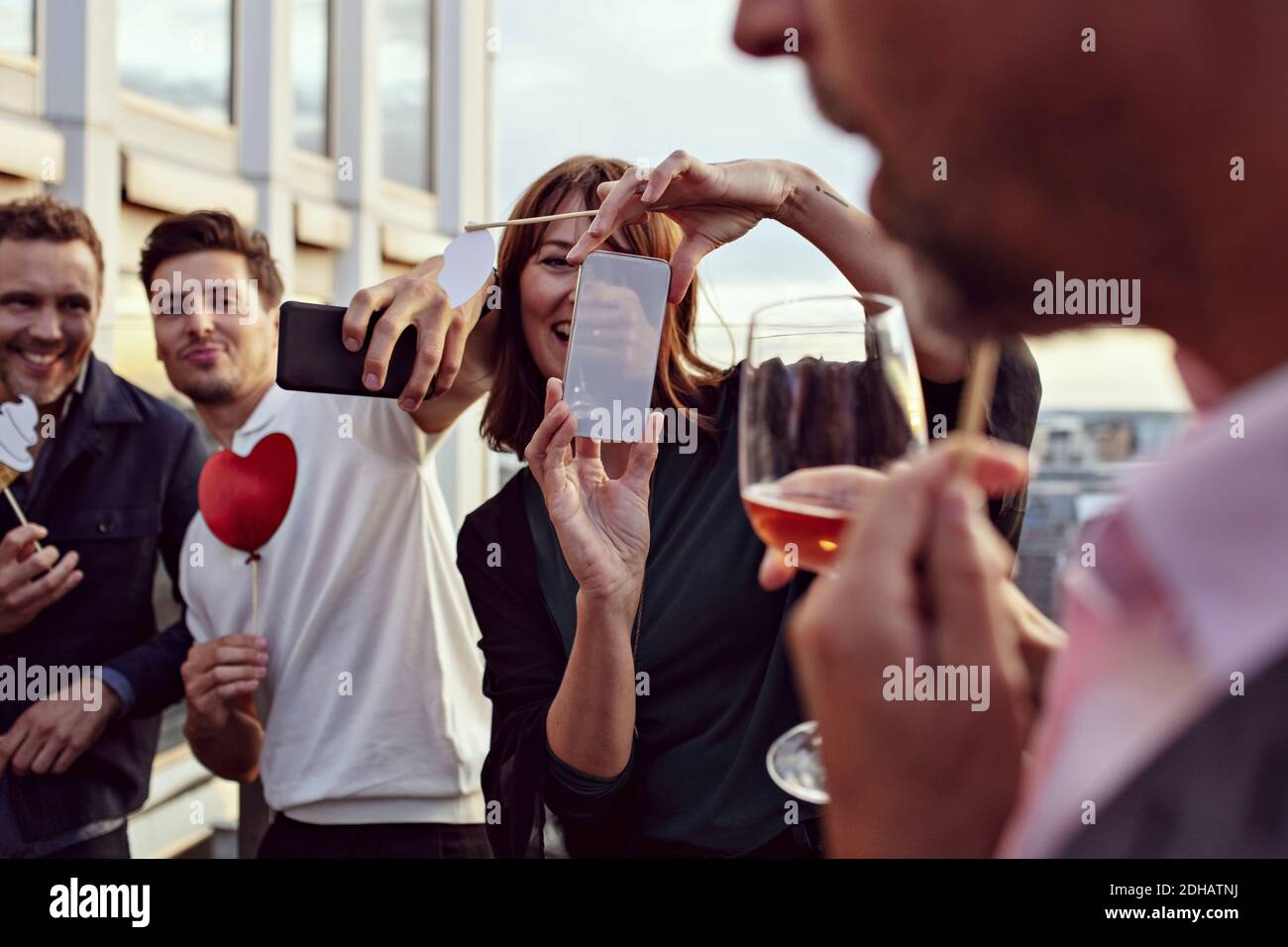 Geschäftskollegen machen Erinnerungen beim Fotografieren mit Smartphones bei Nach der Arbeit Feiern auf der Terrasse Stockfoto