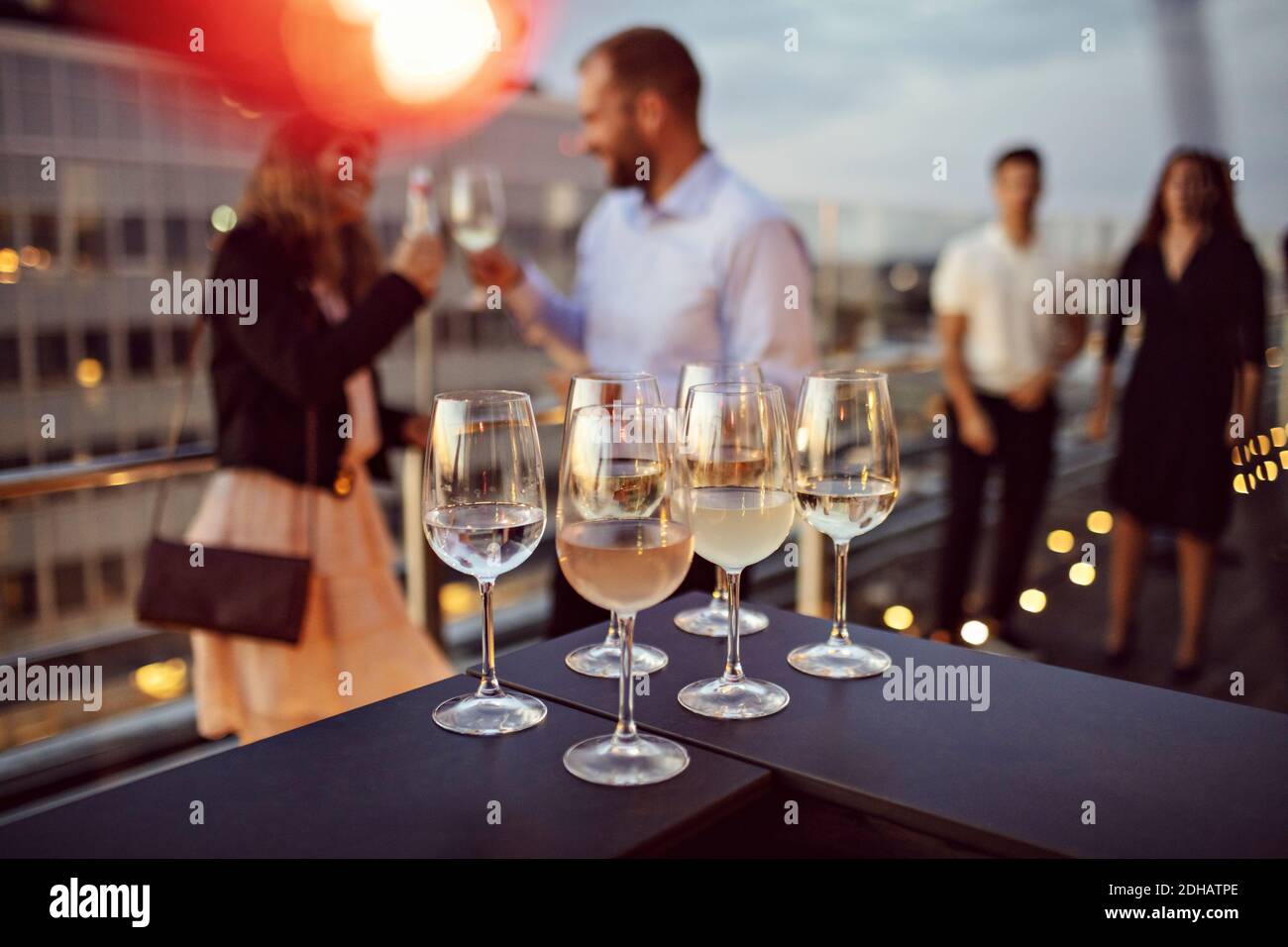 Nahaufnahme der Weingläser auf dem Tisch mit Business-Profis in angeordnet Hintergrund auf der Terrasse während der Party Stockfoto
