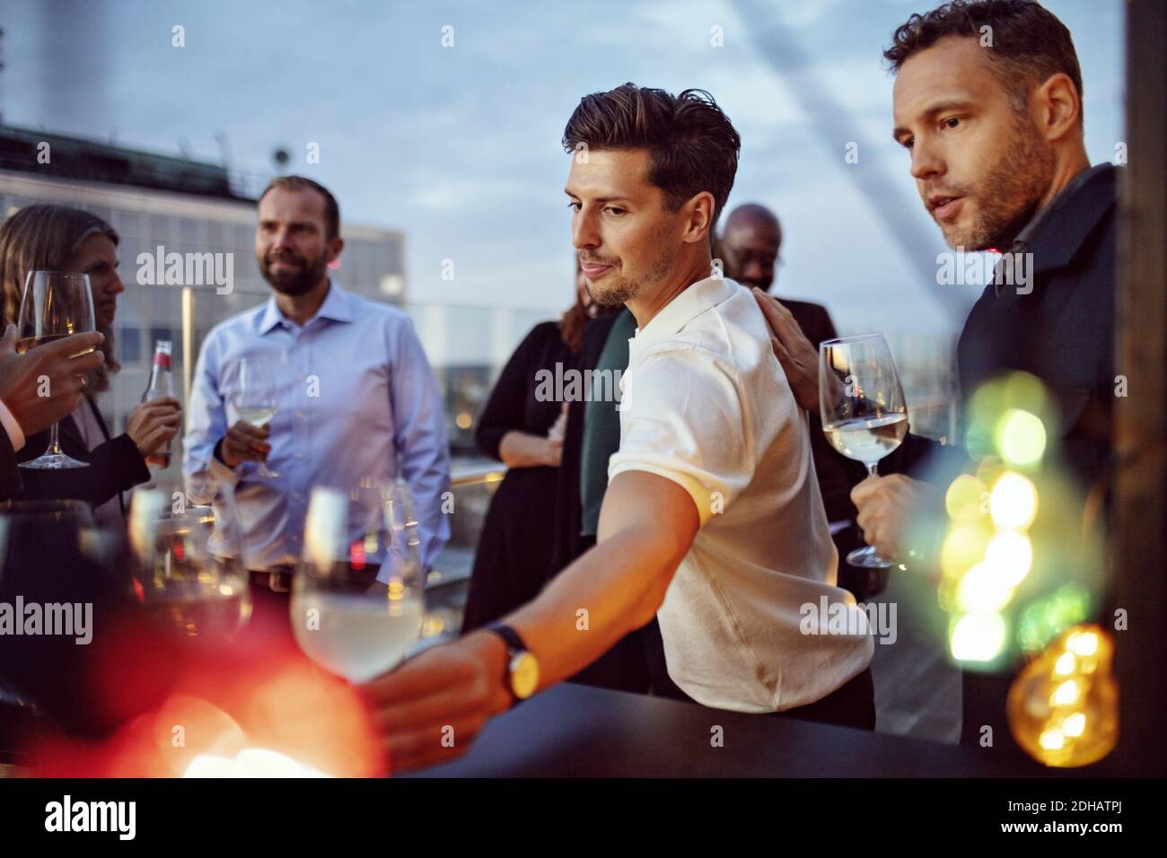 Männliche und weibliche Kollegen, die Wein trinken, während sie Erfolg feiern Party nach der Arbeit Stockfoto