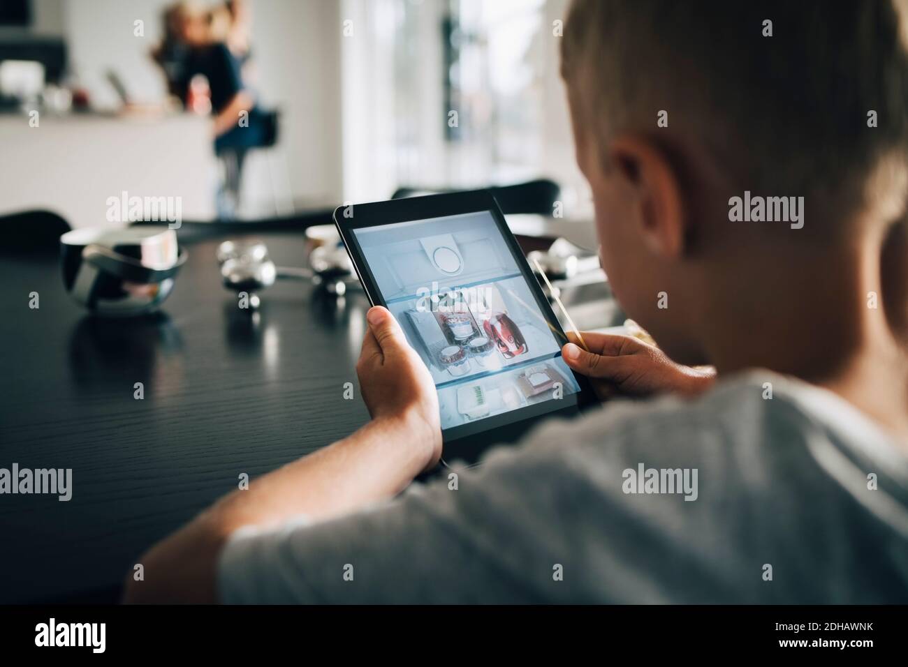 Rückansicht des Jungen mit digitalem Tablet zu Hause Stockfoto
