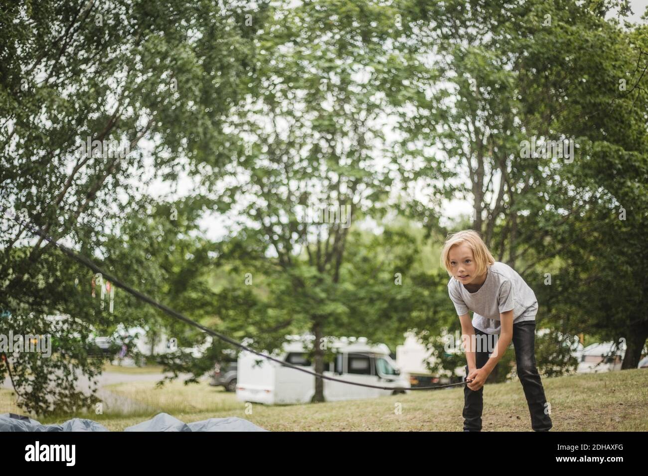 Mädchen Vorbereitung Zelt im Wald auf Campingplatz während der Ferien Stockfoto