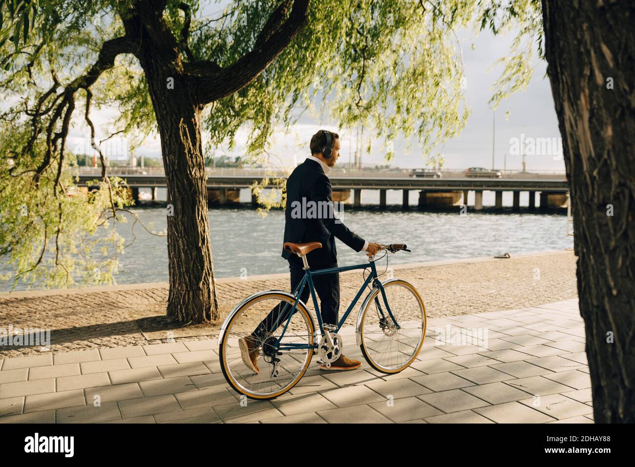 Geschäftsmann zu Fuß mit dem Fahrrad auf dem Fußweg in der Stadt Stockfoto