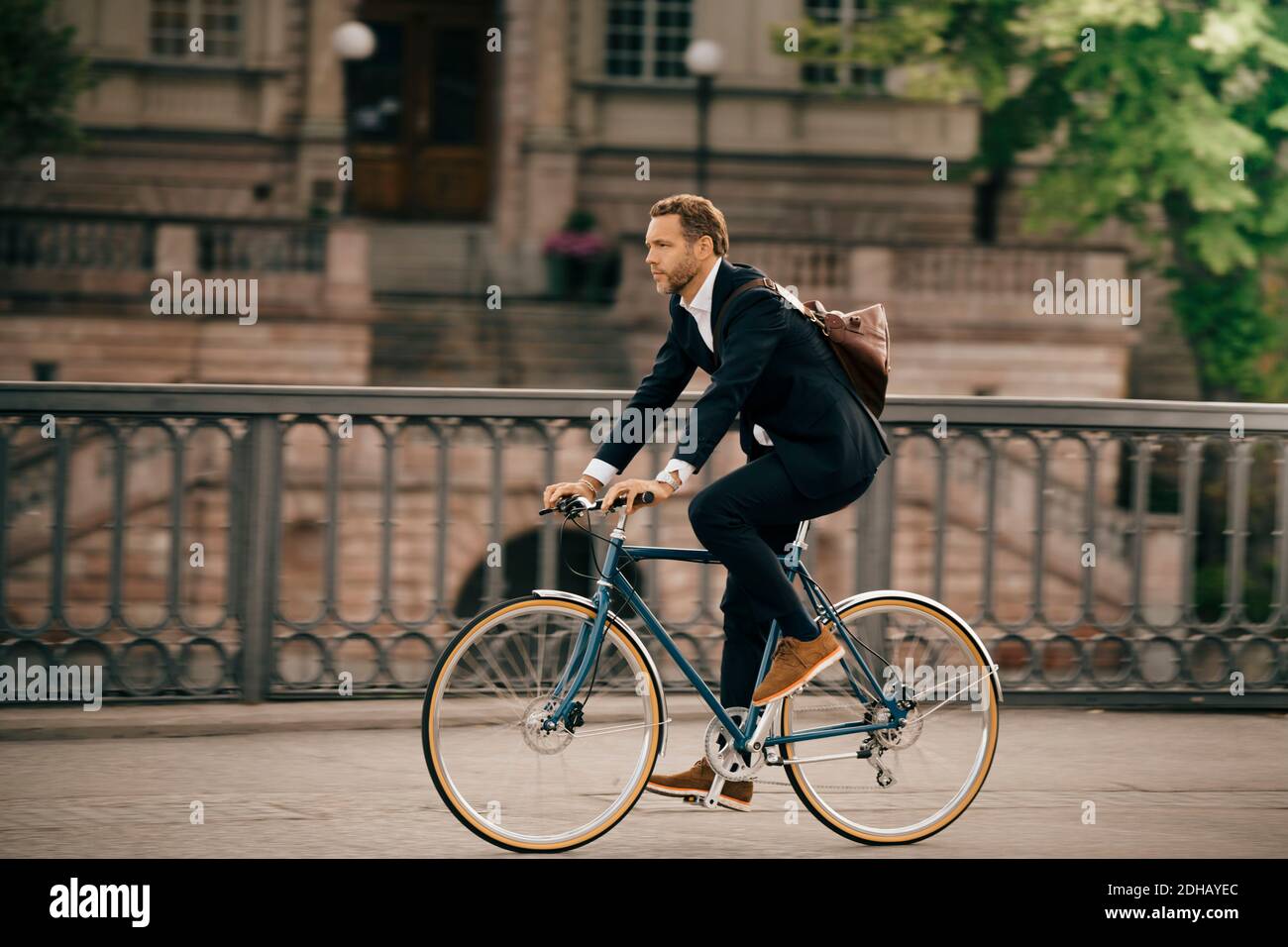 Volle Länge des Geschäftsmannes Radfahren auf der Straße in der Stadt Stockfoto
