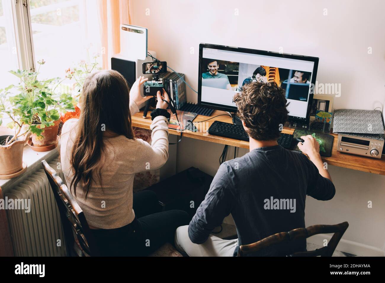 High-Angle-Ansicht von Freunden blogging über die Kamera während der Suche Auf dem Smartphone im Haus Stockfoto