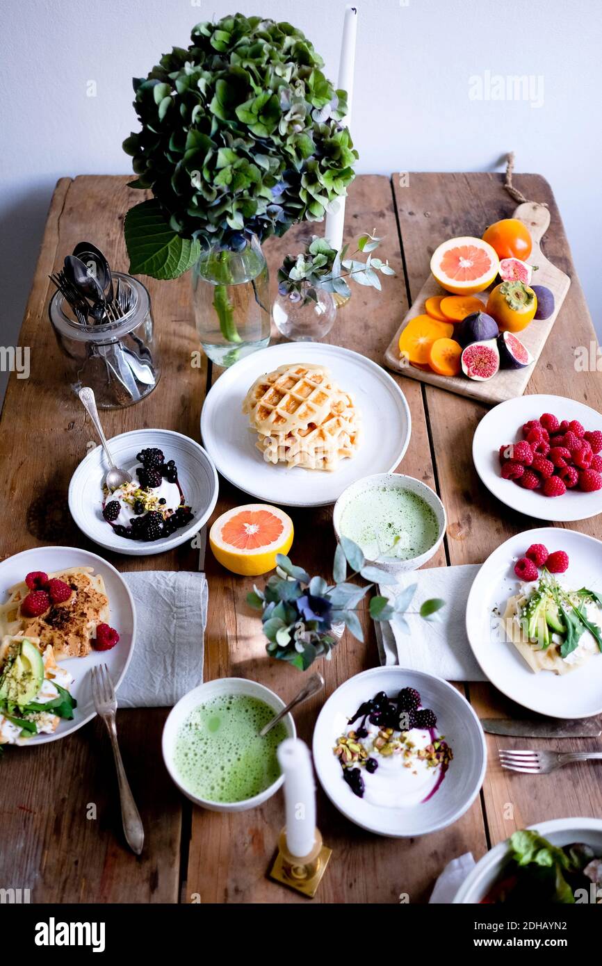 High-Winkel-Ansicht von verschiedenen Lebensmitteln auf Holztisch durch Wand Stockfoto