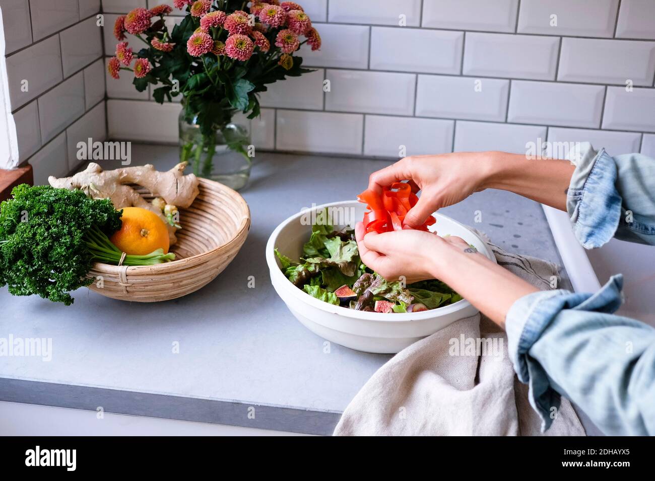 Zugeschnittenes Bild einer Frau, die Salat an der Küchentheke macht Stockfoto