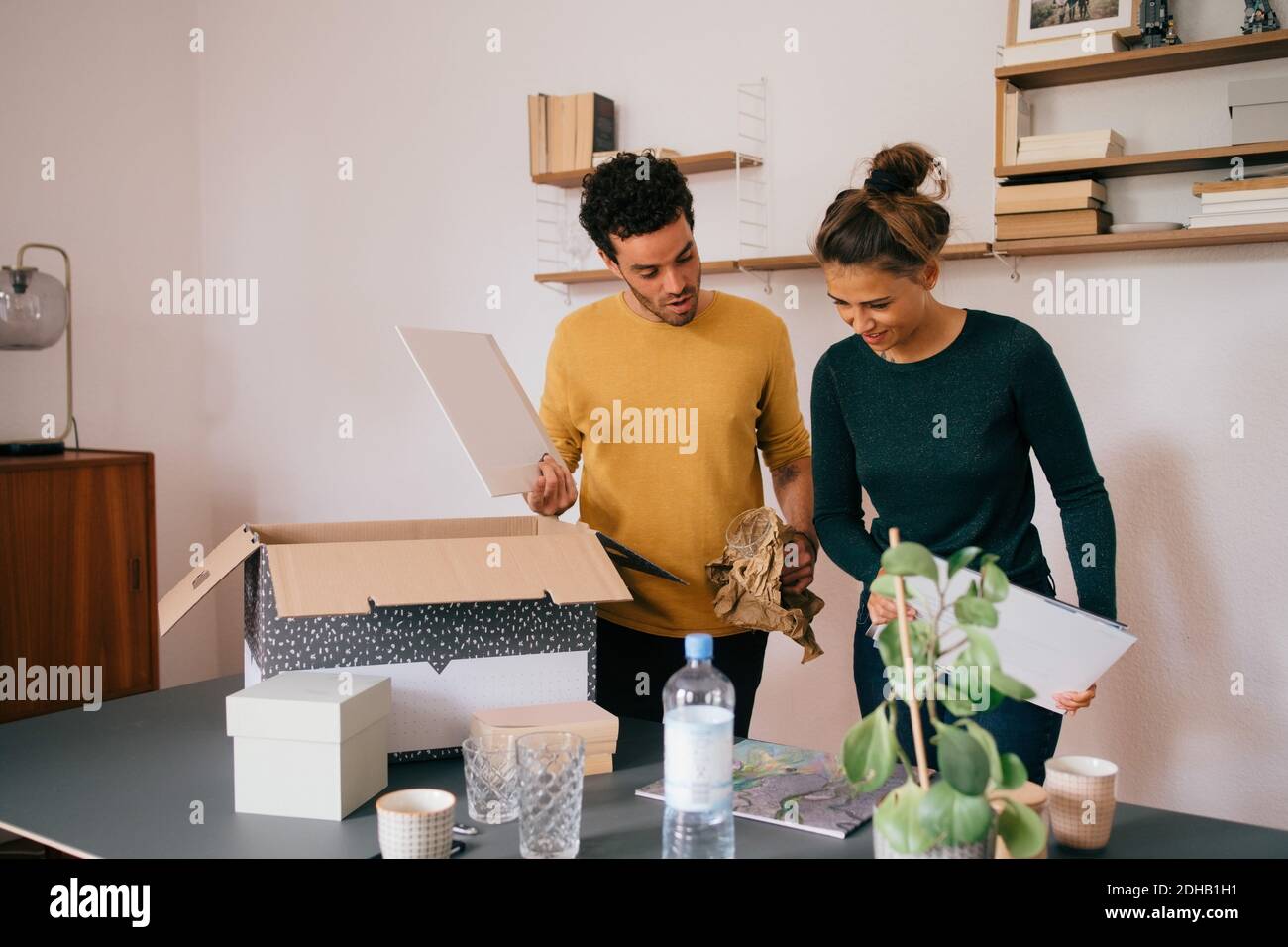 Freund und Freundin Auspacken Bücher zu Hause neu Stockfoto