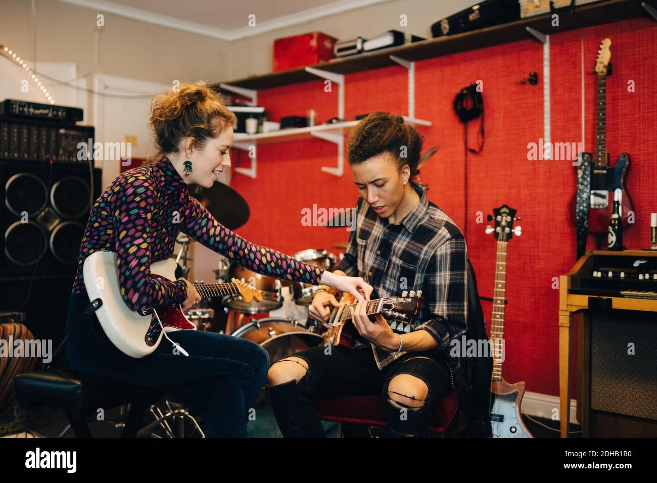 Freunde spielen Gitarren während der Übung im Aufnahmestudio Stockfoto