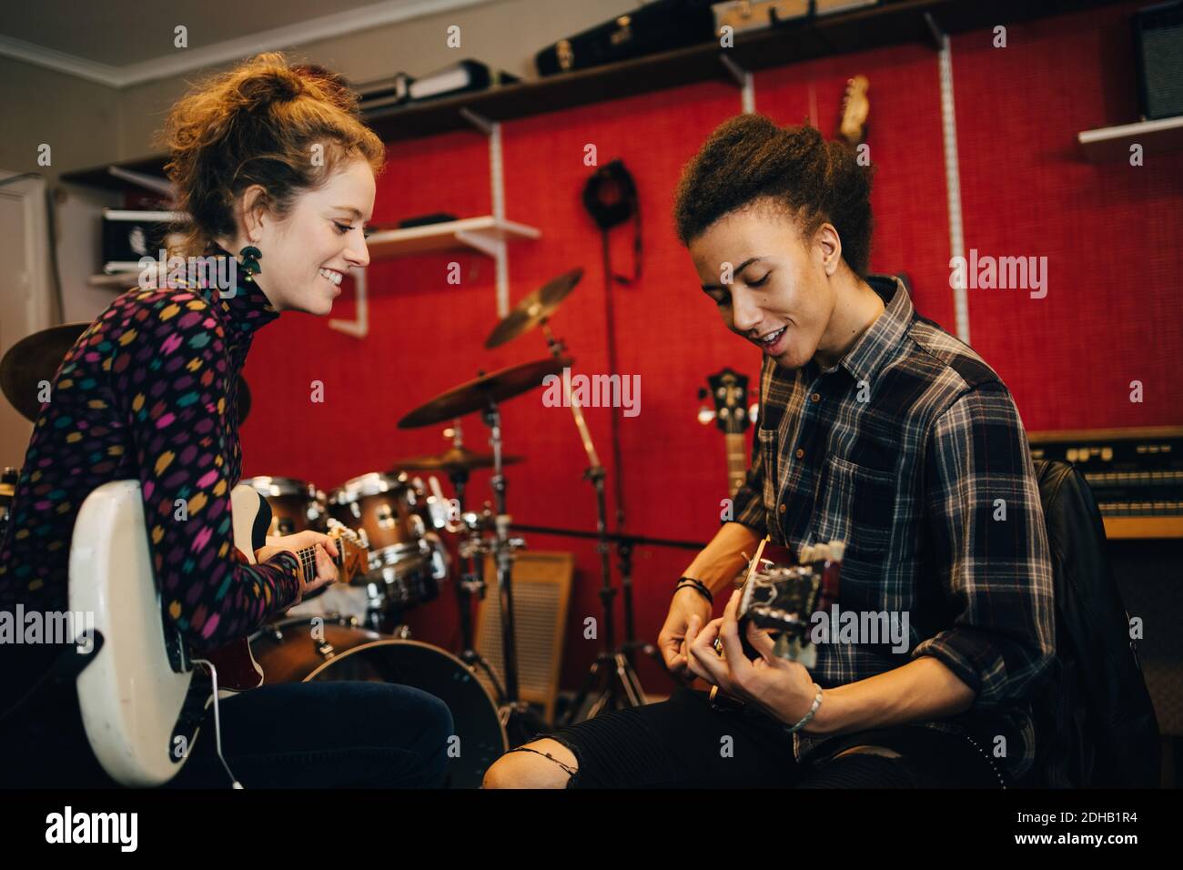 Freunde spielen Gitarren während der Übung im Aufnahmestudio Stockfoto