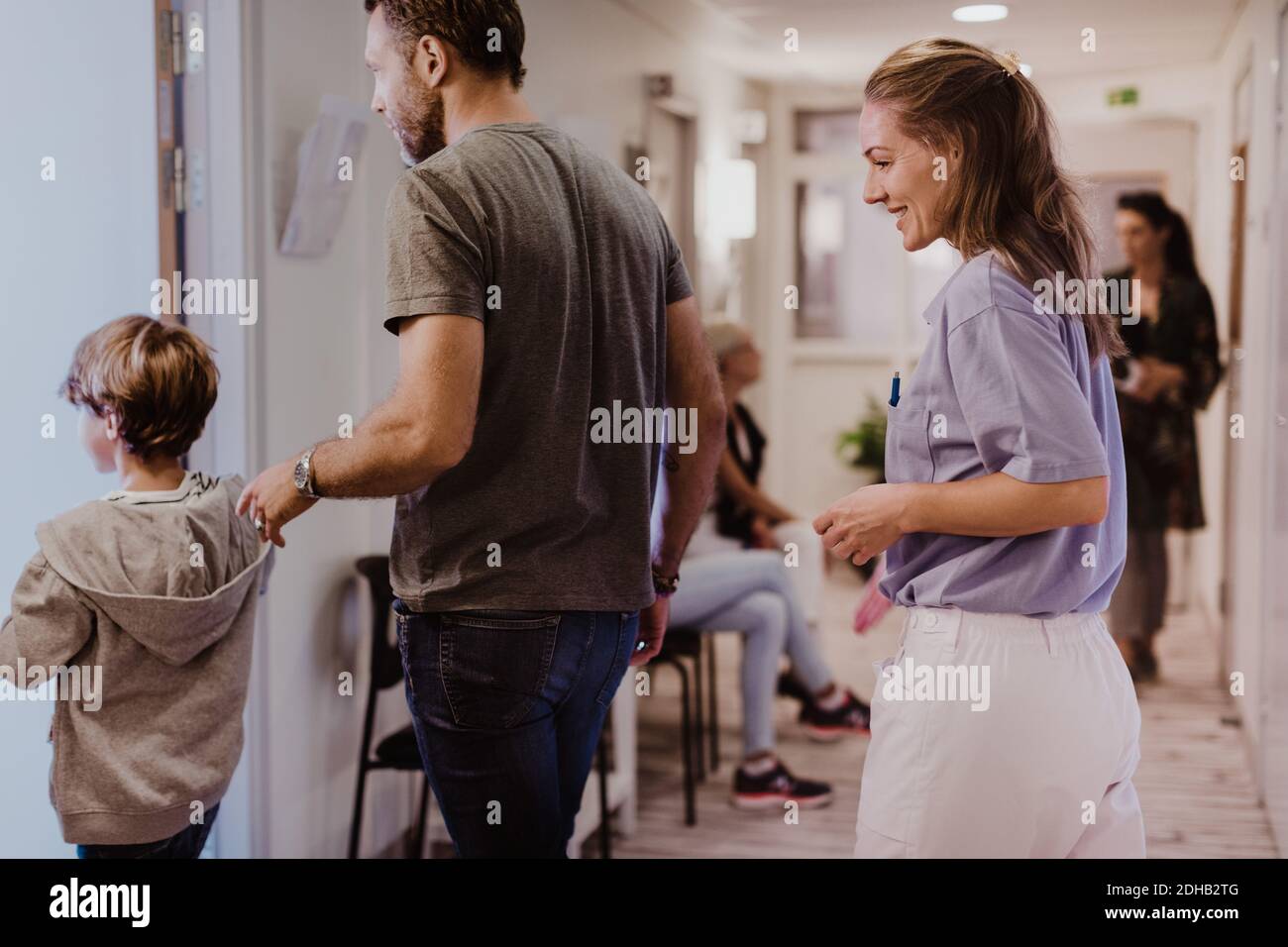 Ärztin beim Betreten des medizinischen Zimmers mit Patienten im Krankenhaus Stockfoto