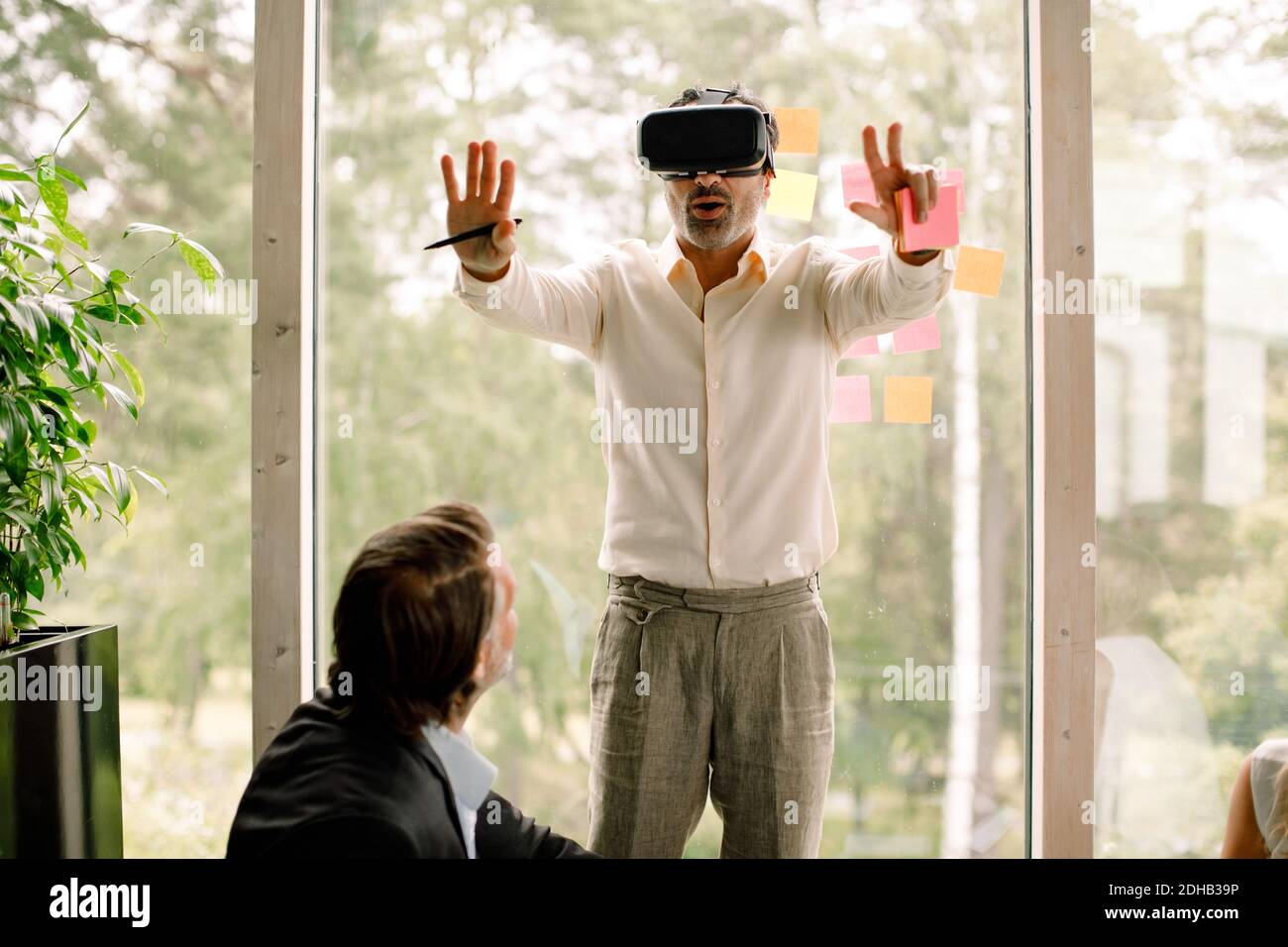 Geschäftsmann gestikulieren, während das Tragen Virtual Reality-Simulator während der Konferenz an kongresszentrum Stockfoto