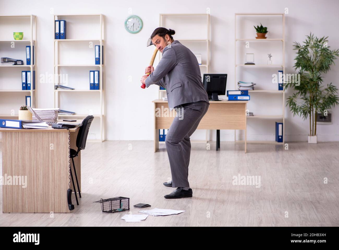 Junger männlicher Angestellter und Mausefalle im Büro Stockfoto