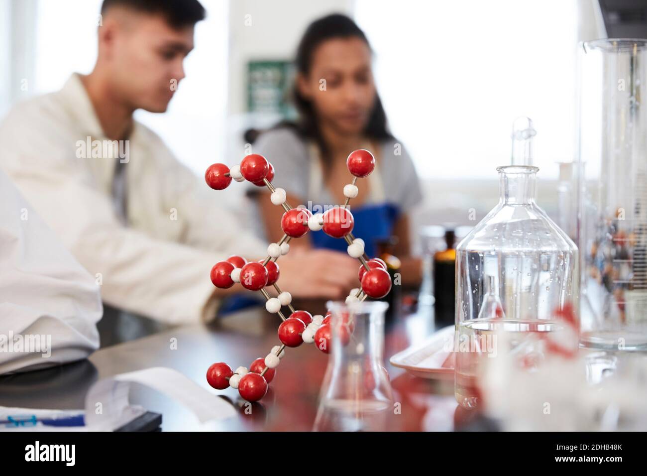 Molekulare Struktur auf dem Tisch gegen junge Studenten im Chemielabor Stockfoto